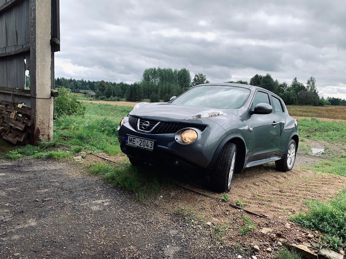 Nissan juke ir novietots uz zemes ceļa laukā.