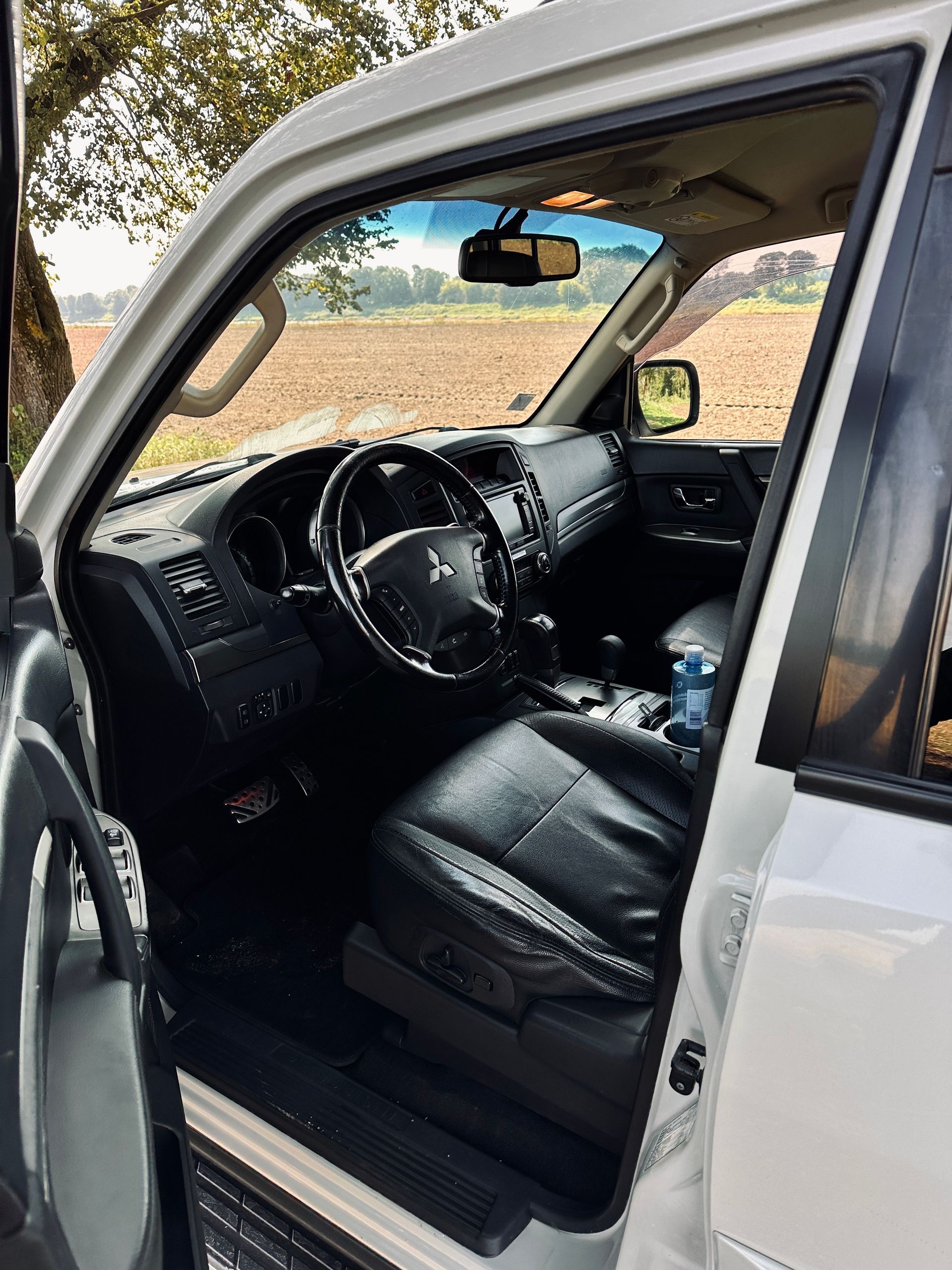 Balta mitsubishi pajero iekšpuse ar atvērtām durvīm.