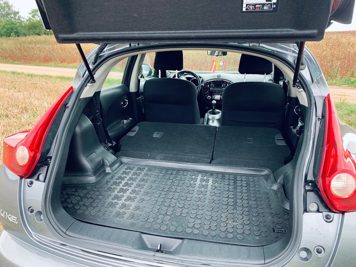 Automašīnas aizmugure ar atvērtu bagāžnieku un nolaistiem sēdekļiem.