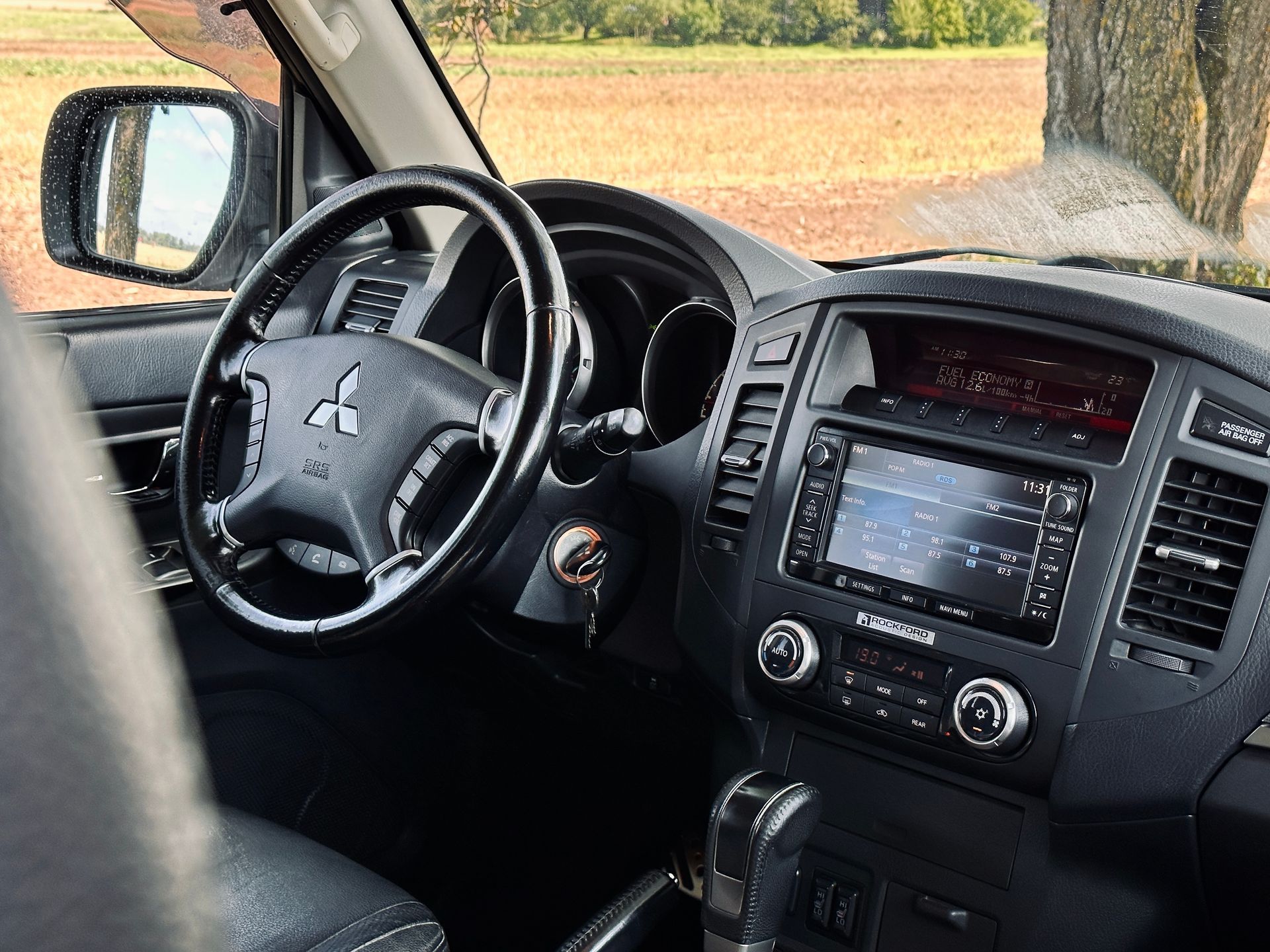 Interjers mitsubishi pajero ar stūri un radio.