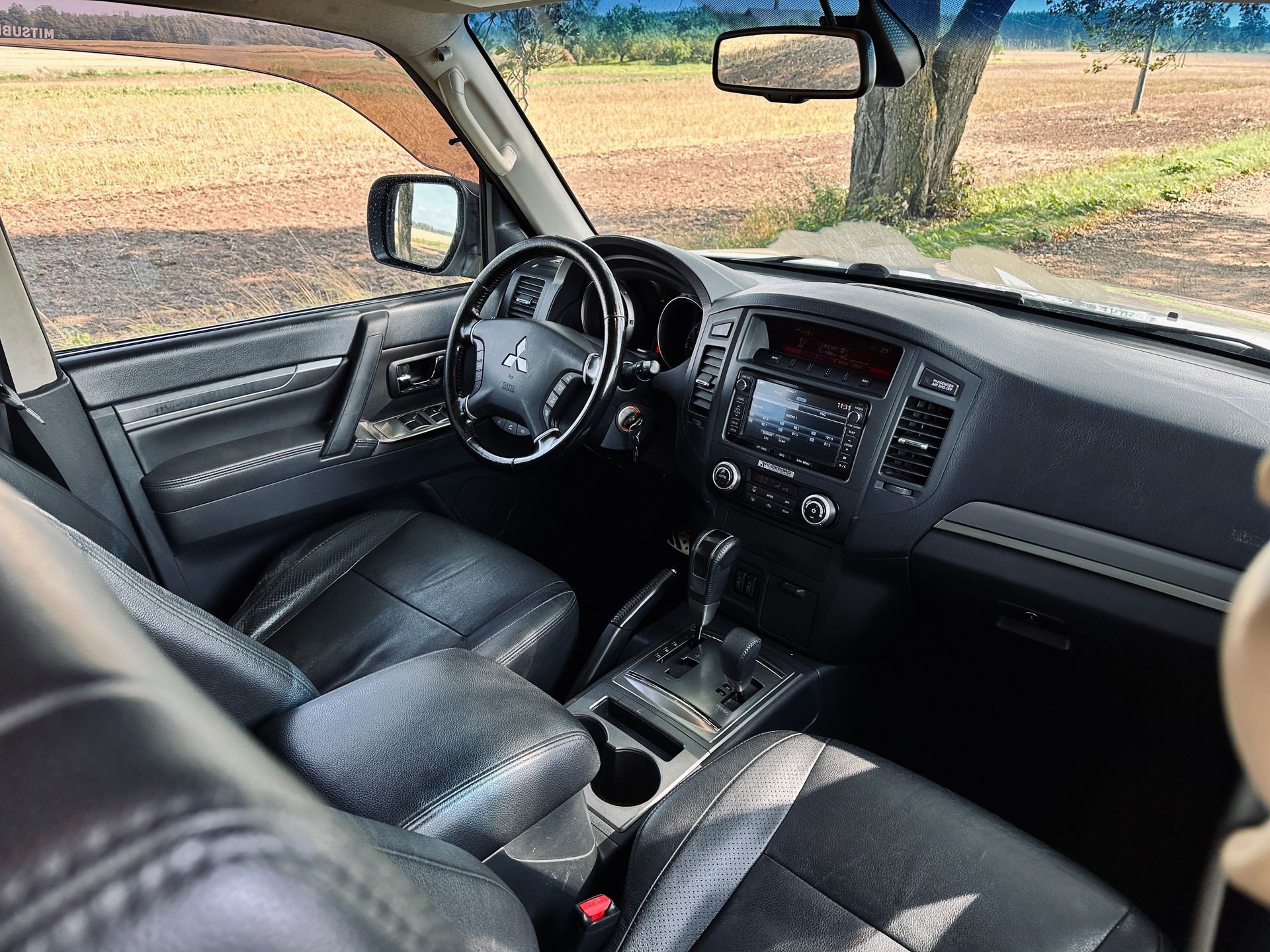 Automašīnas iekšpuse ar stūri un instrumentu paneli.