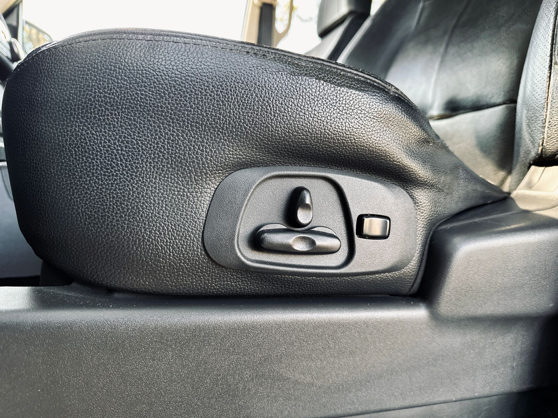 Tuvplāns no automašīnas sēdekļa ar pogu uz tā.