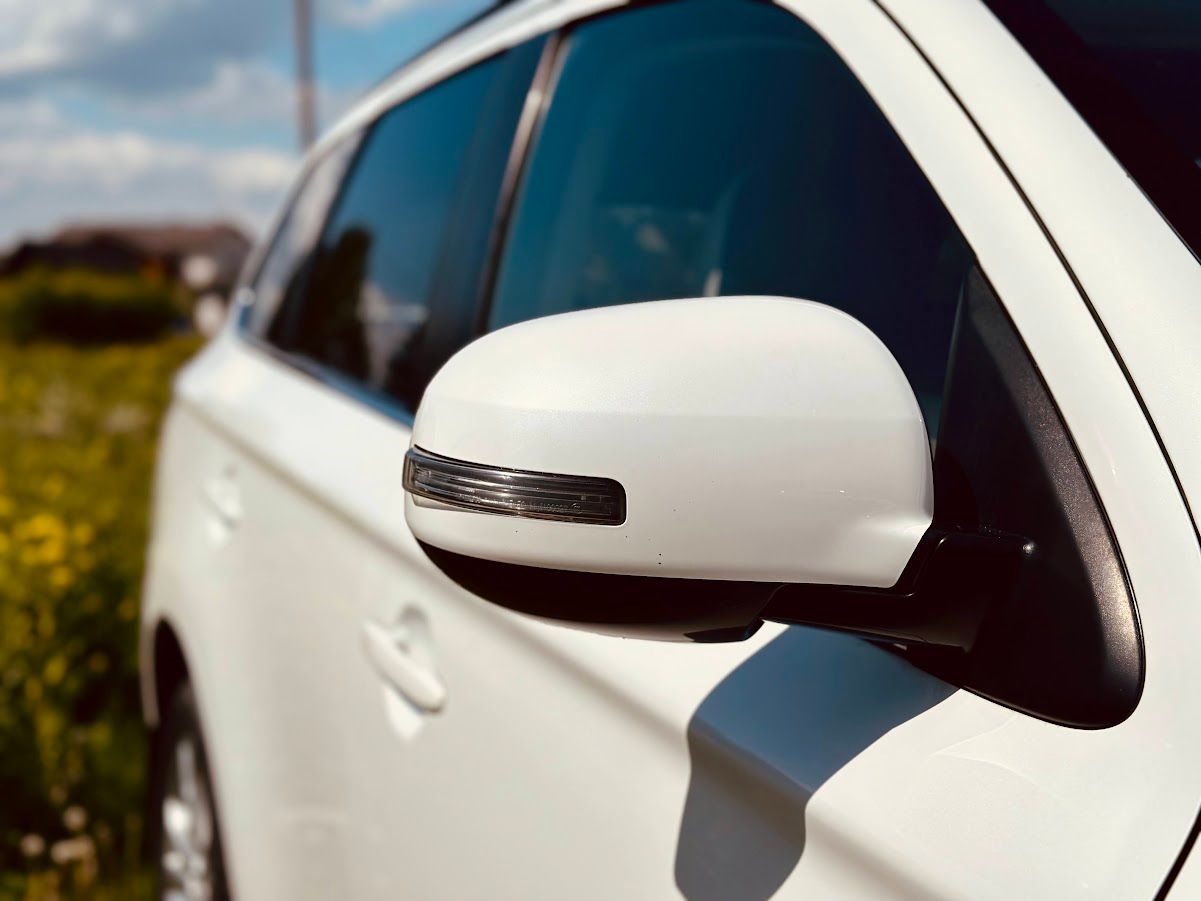 Tuvplāns sānskata spogulim uz baltas automašīnas