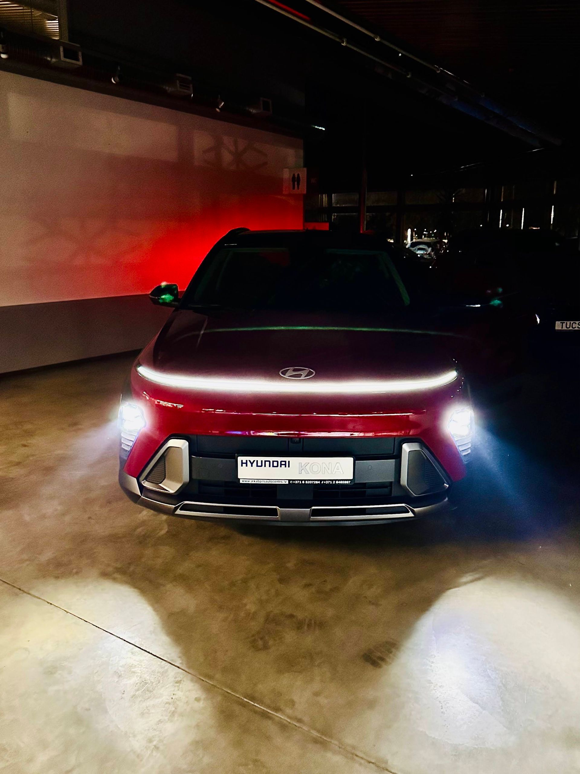 Pa nakti stāv garāžā sarkana mašīna.