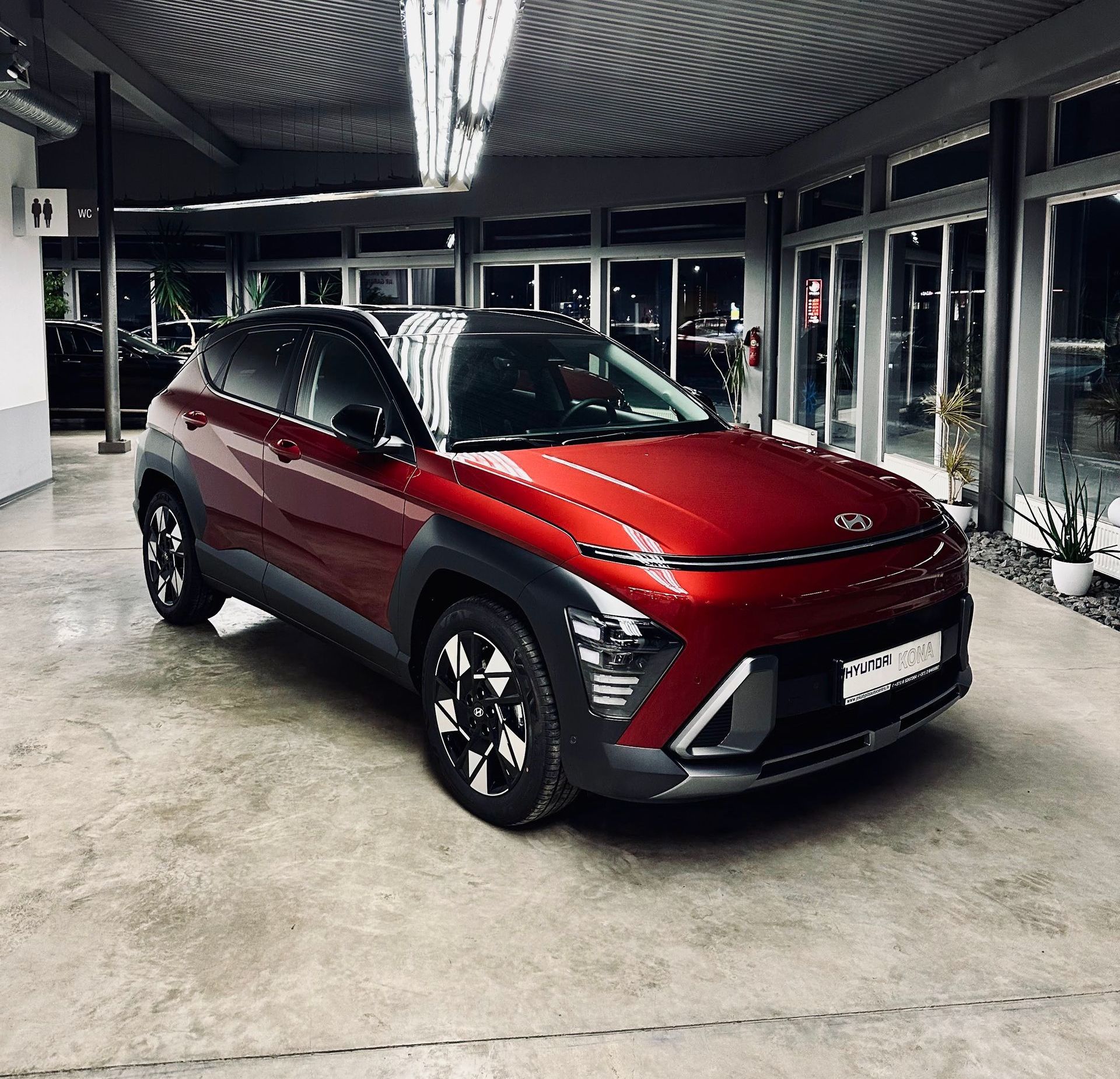 Autostāvvietā stāv sarkana automašīna