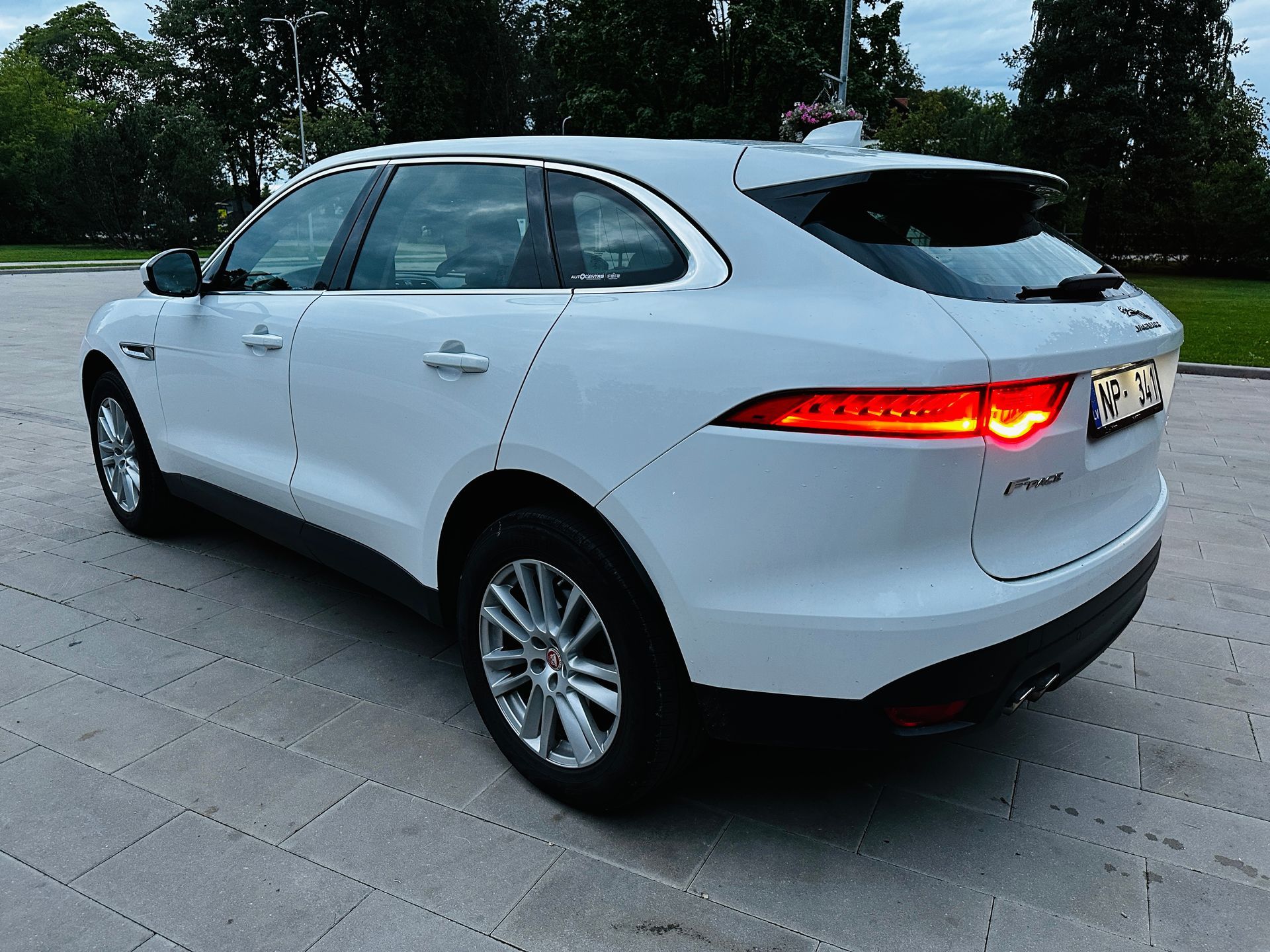 Balts jaguārs f pace ir novietots uz ietves