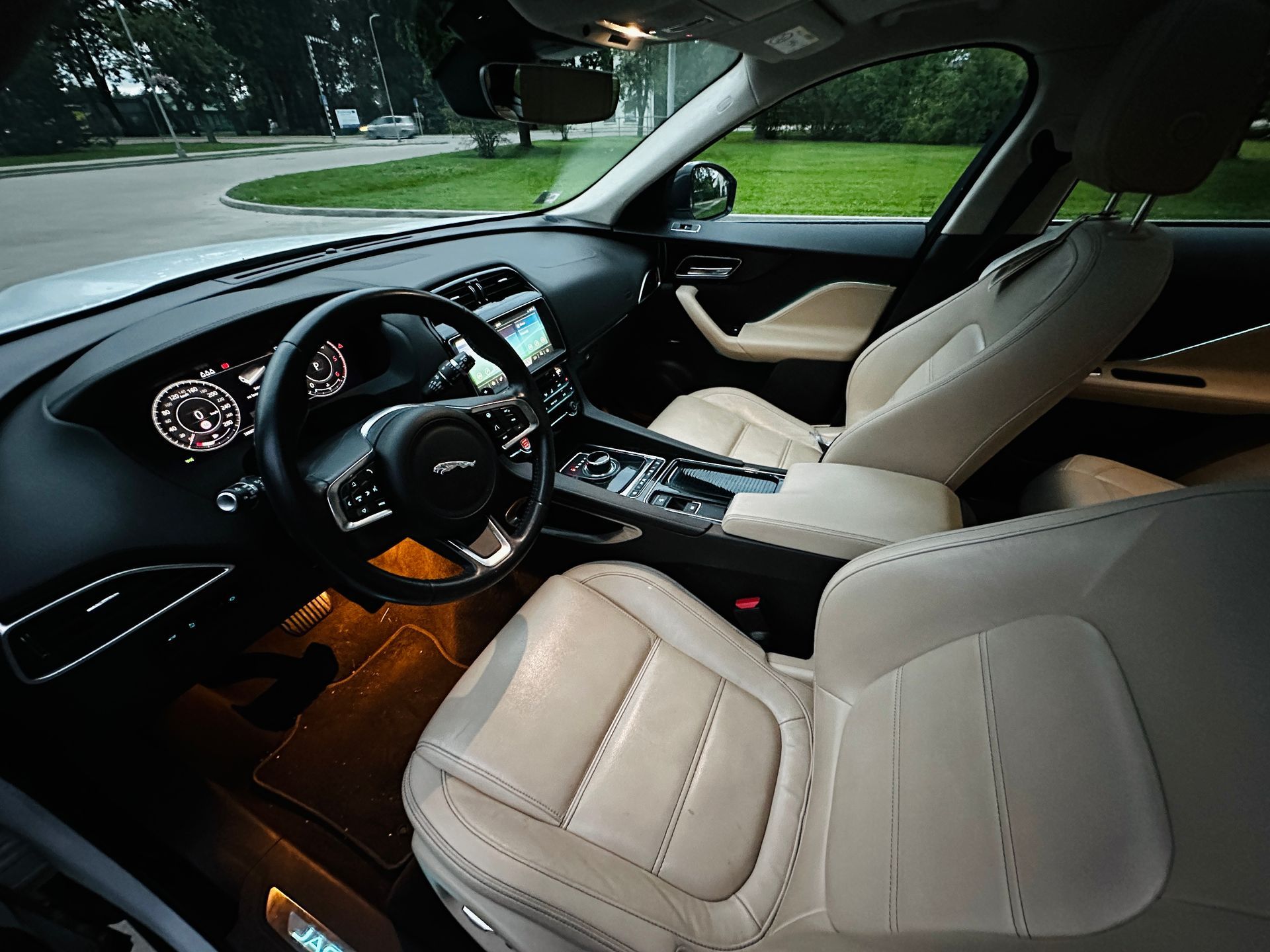 Automašīnas salons ar baltiem ādas sēdekļiem un stūri