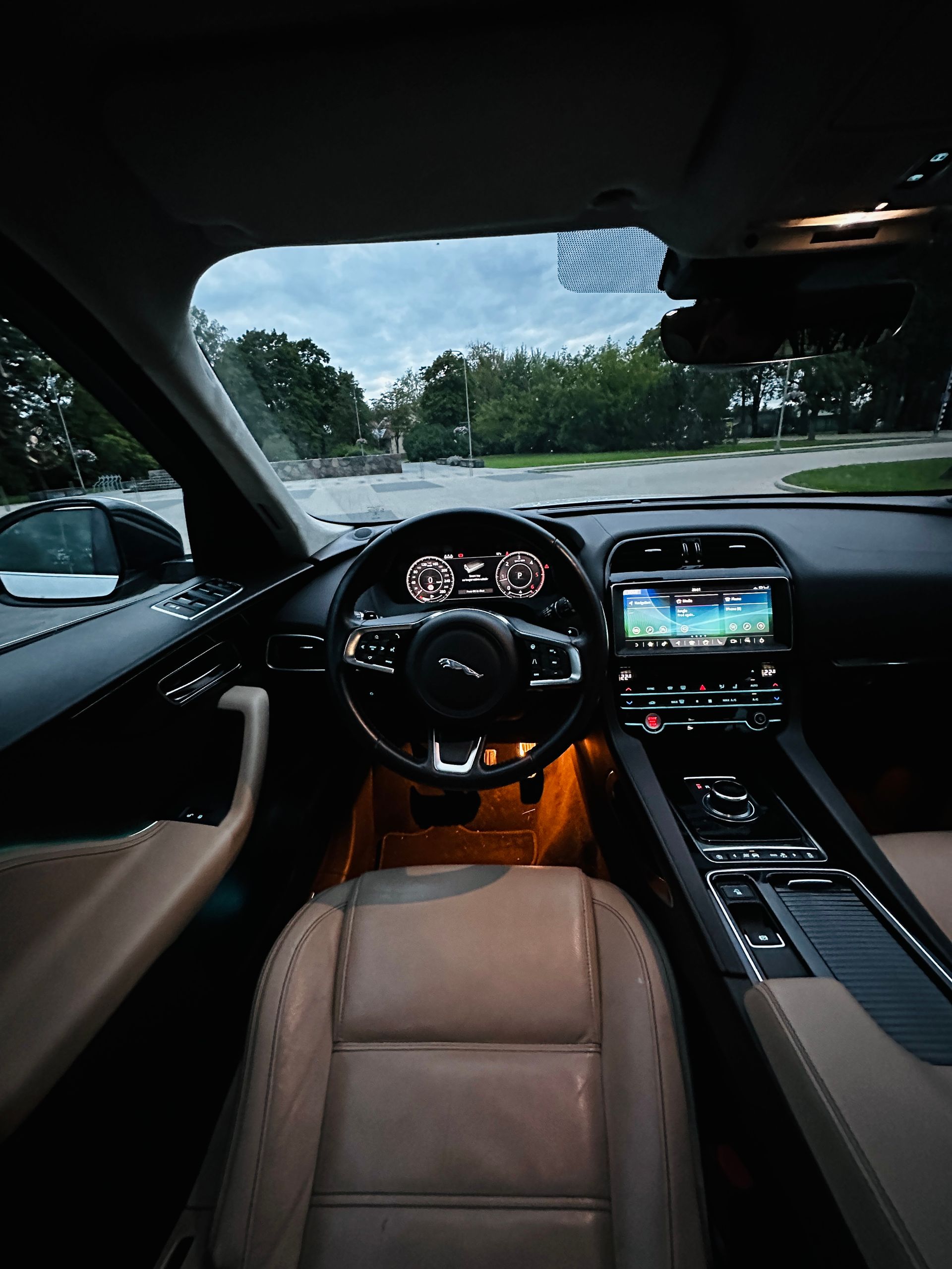 Automašīnas iekšpuse ar stūri un instrumentu paneli.