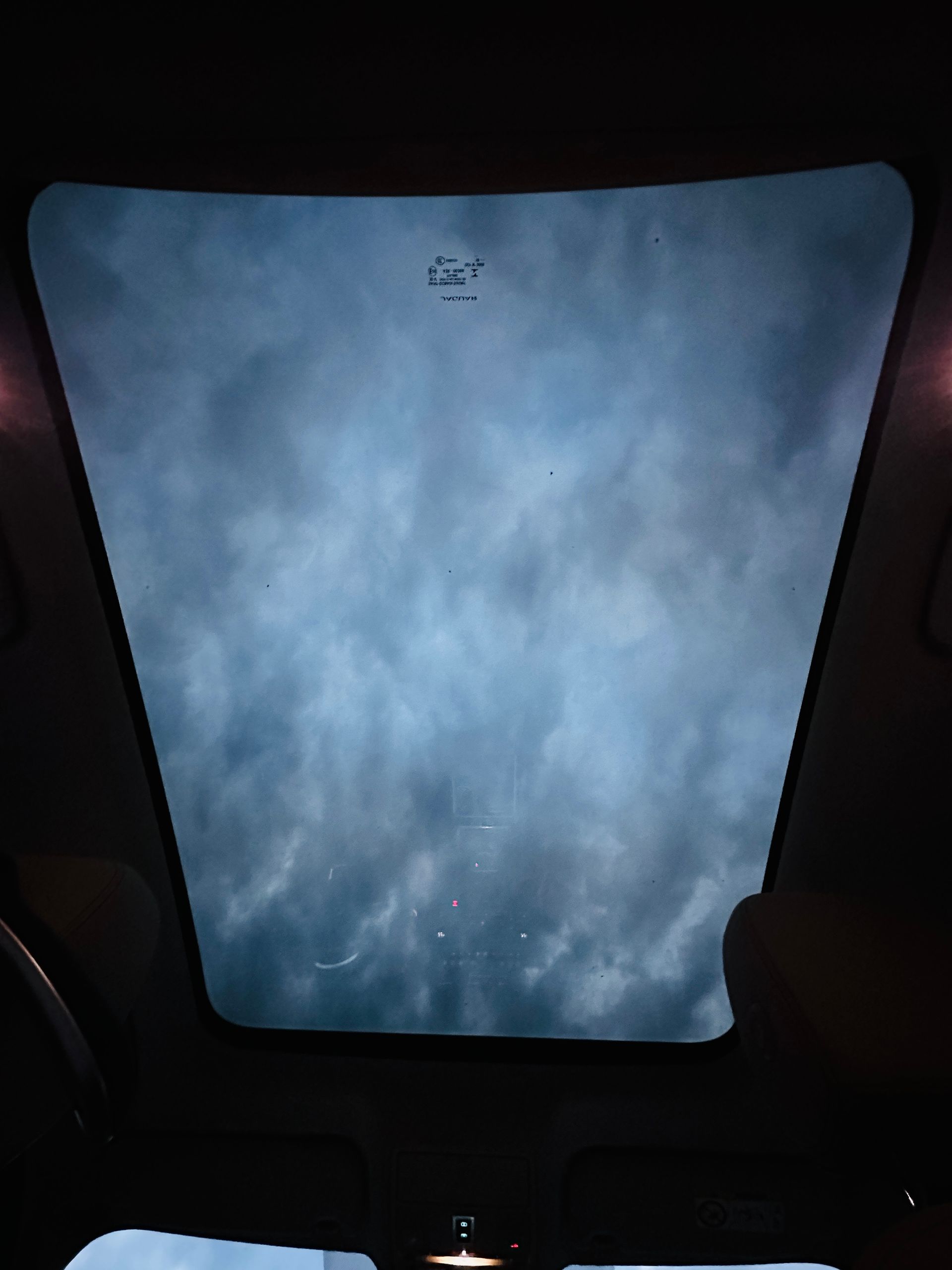 Debesis ir redzamas caur automašīnas jumta lūku