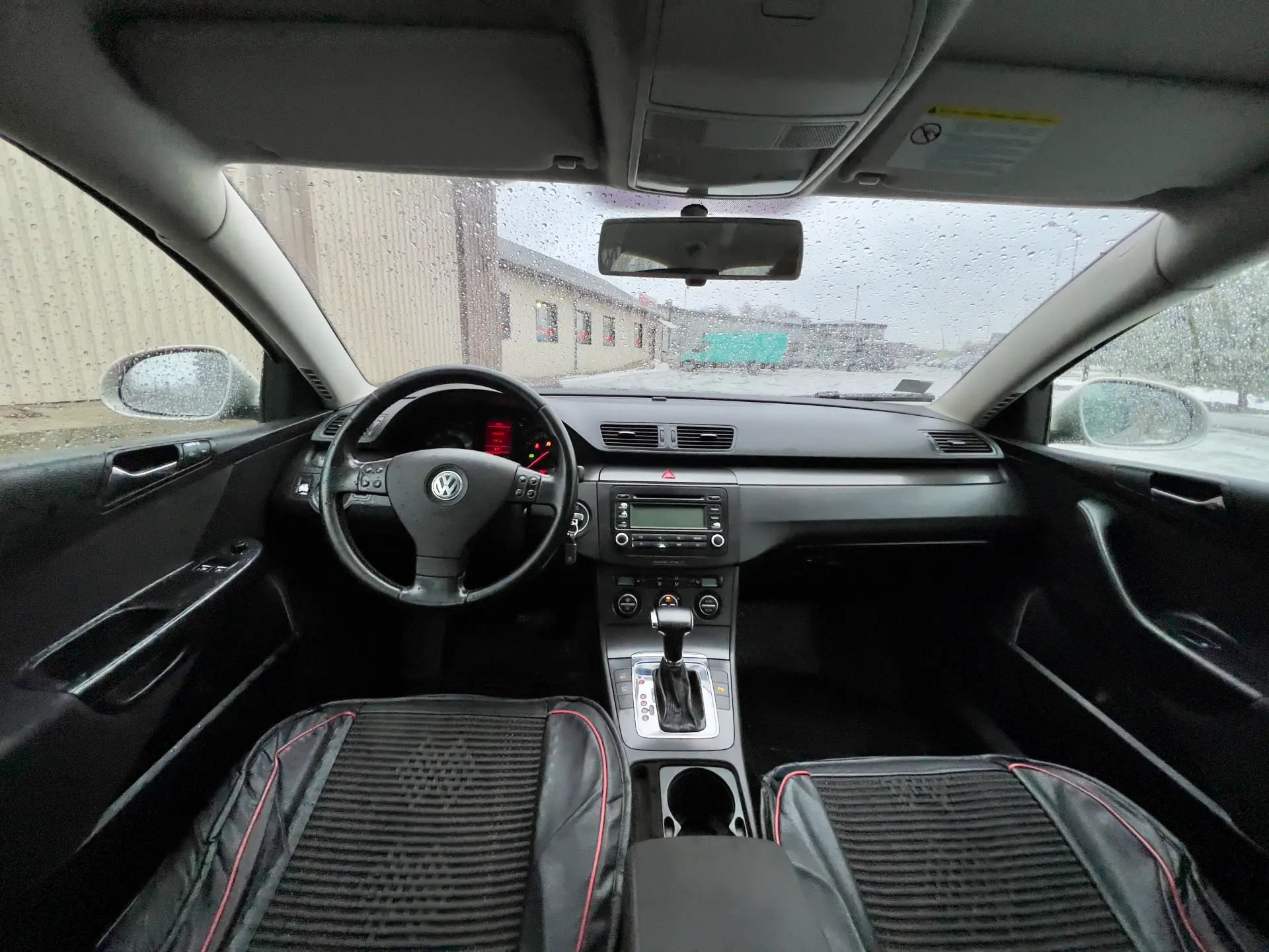 Automašīnas salons ar stūri un instrumentu paneli.