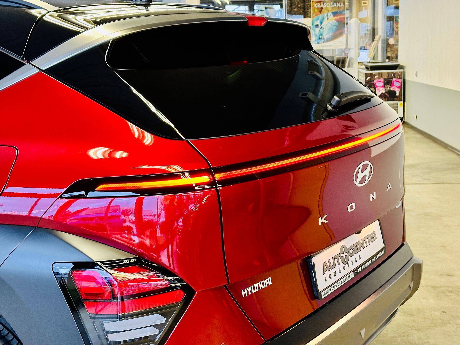 Sarkana hyundai kona ir novietota izstāžu zālē.