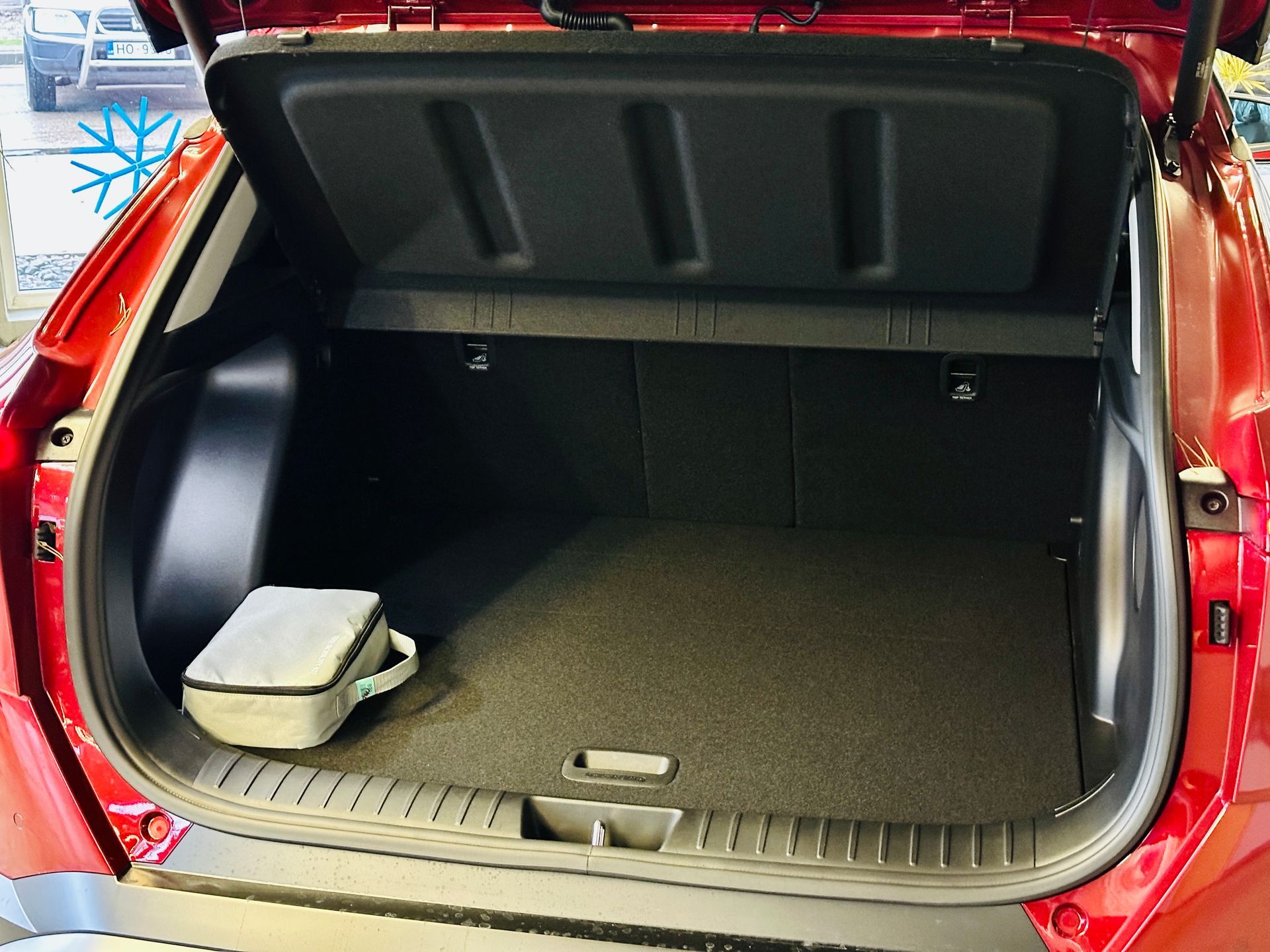 Sarkanas automašīnas bagāžnieks ar atvērtu bagāžnieka vāku