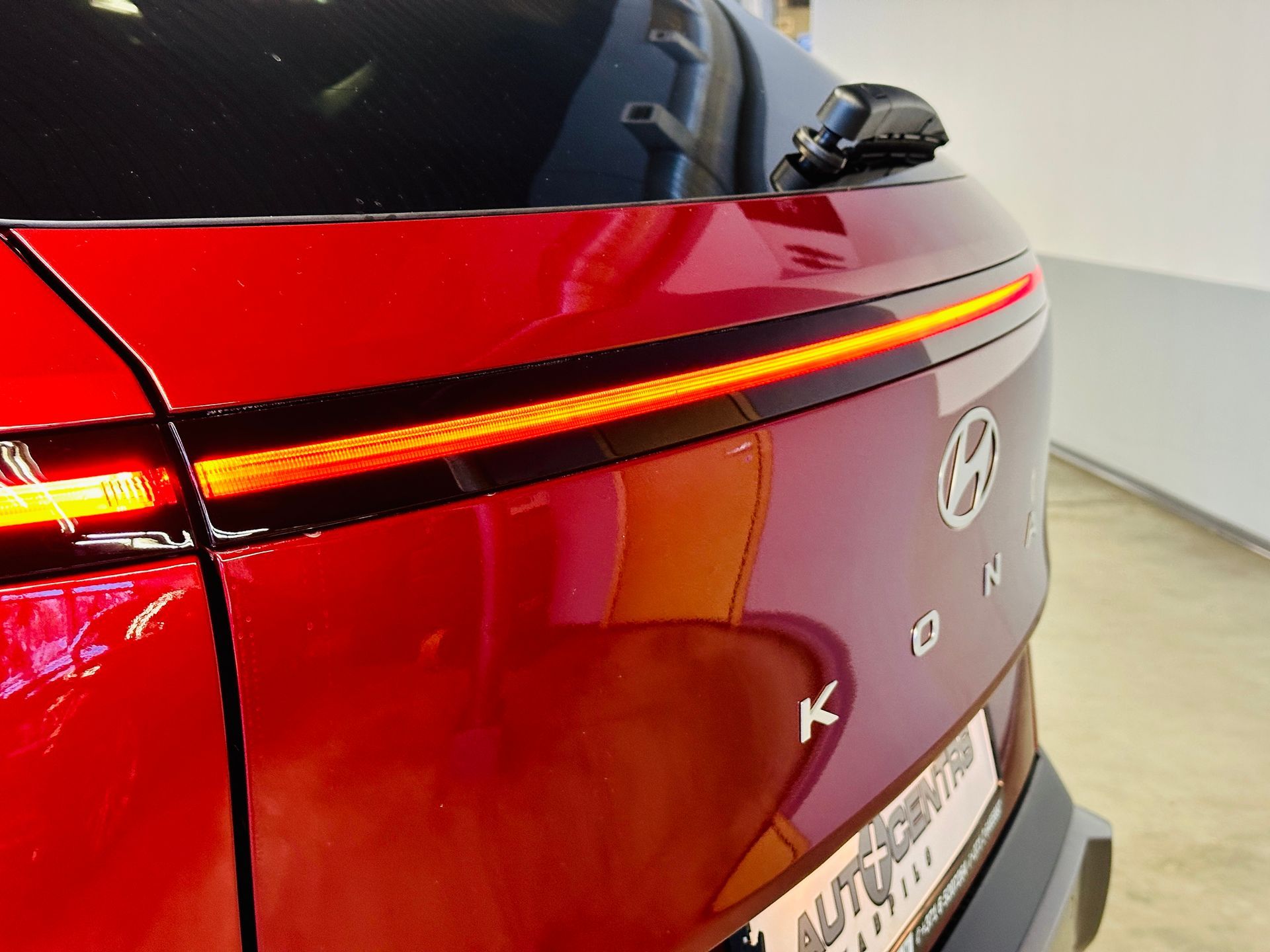 Sarkana mašīna ar numura zīmi, kurā rakstīts autoserviss