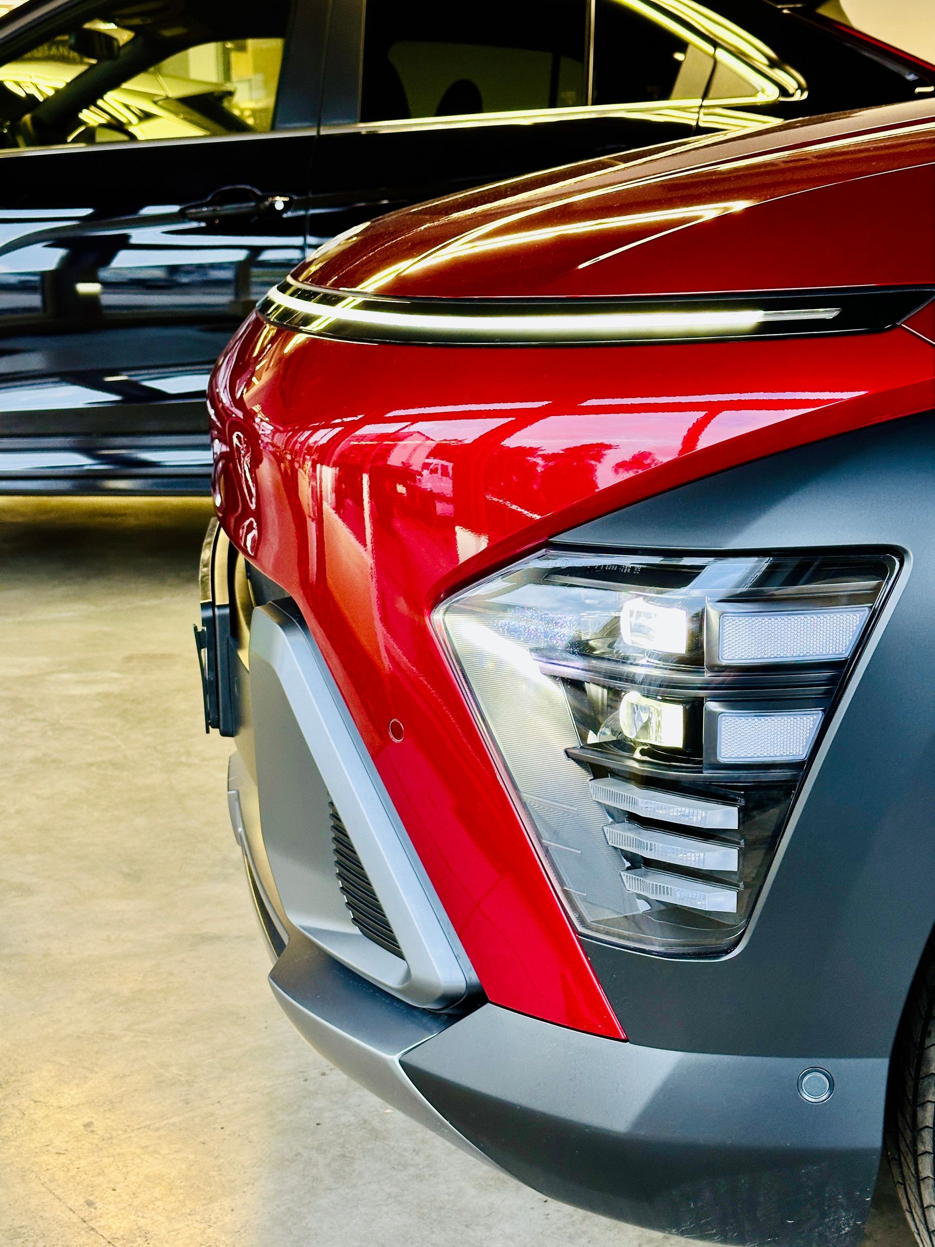 Sarkana mašīna stāv pie melnas mašīnas