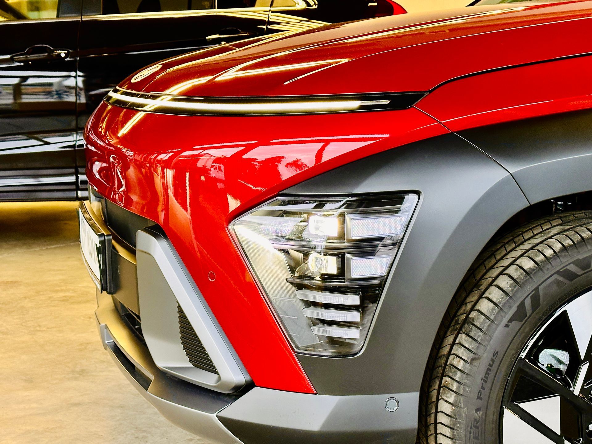 Sarkana mašīna ir novietota pie melnas automašīnas salonā.