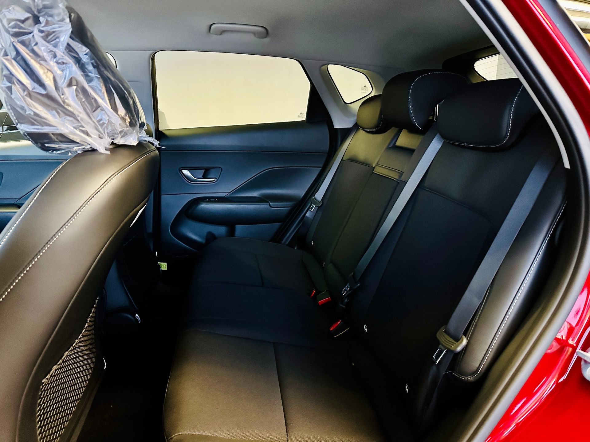 Sarkanas automašīnas aizmugurējais sēdeklis ar melniem sēdekļiem