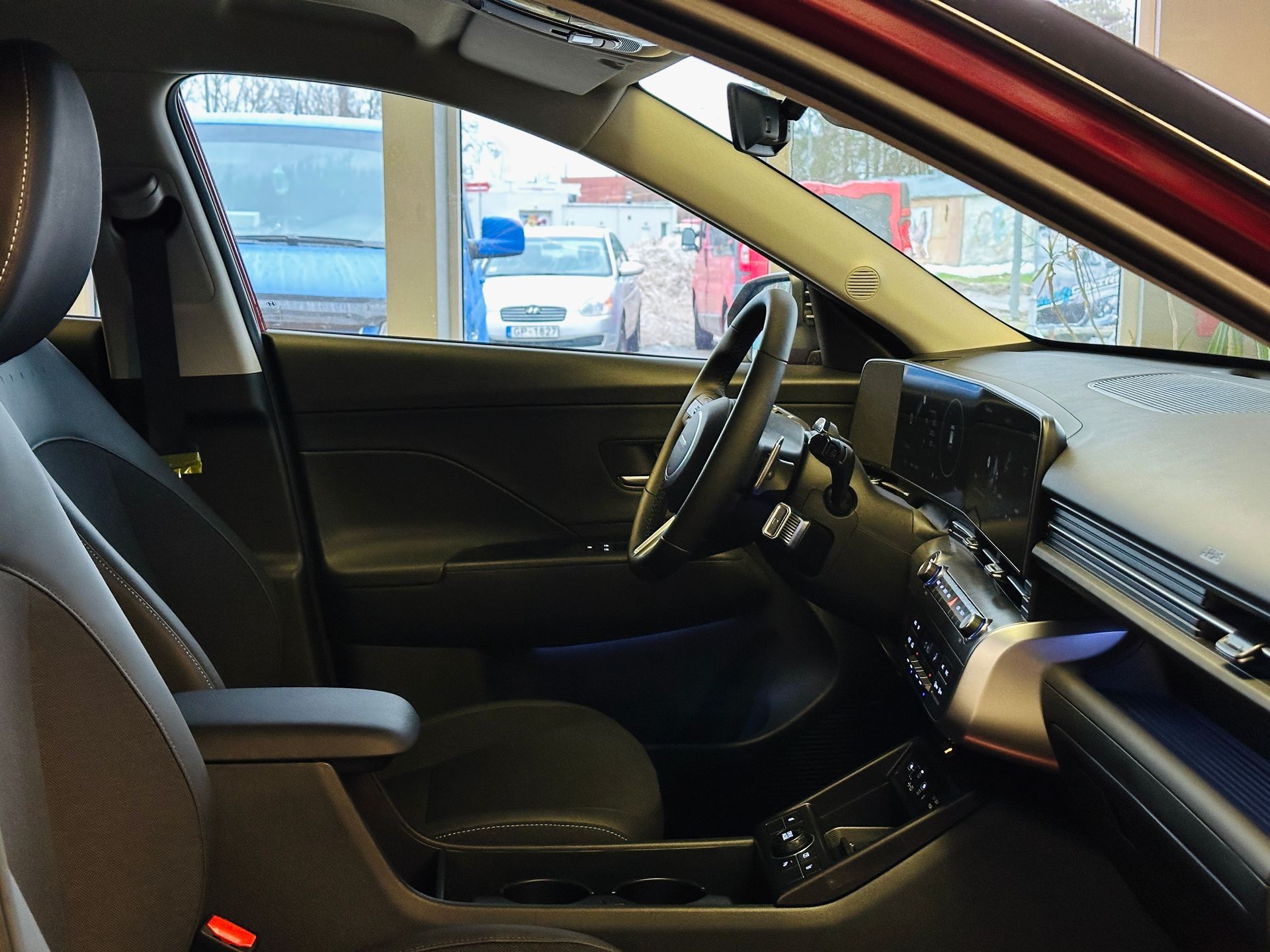 Sarkanas automašīnas iekšpuse ar atvērtām durvīm