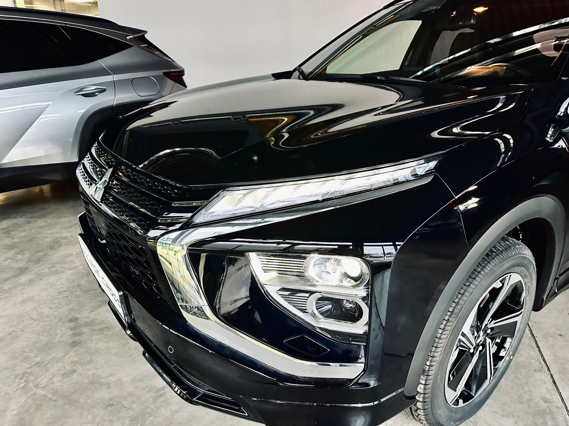 Melna mašīna stāv pie sudraba krāsas auto