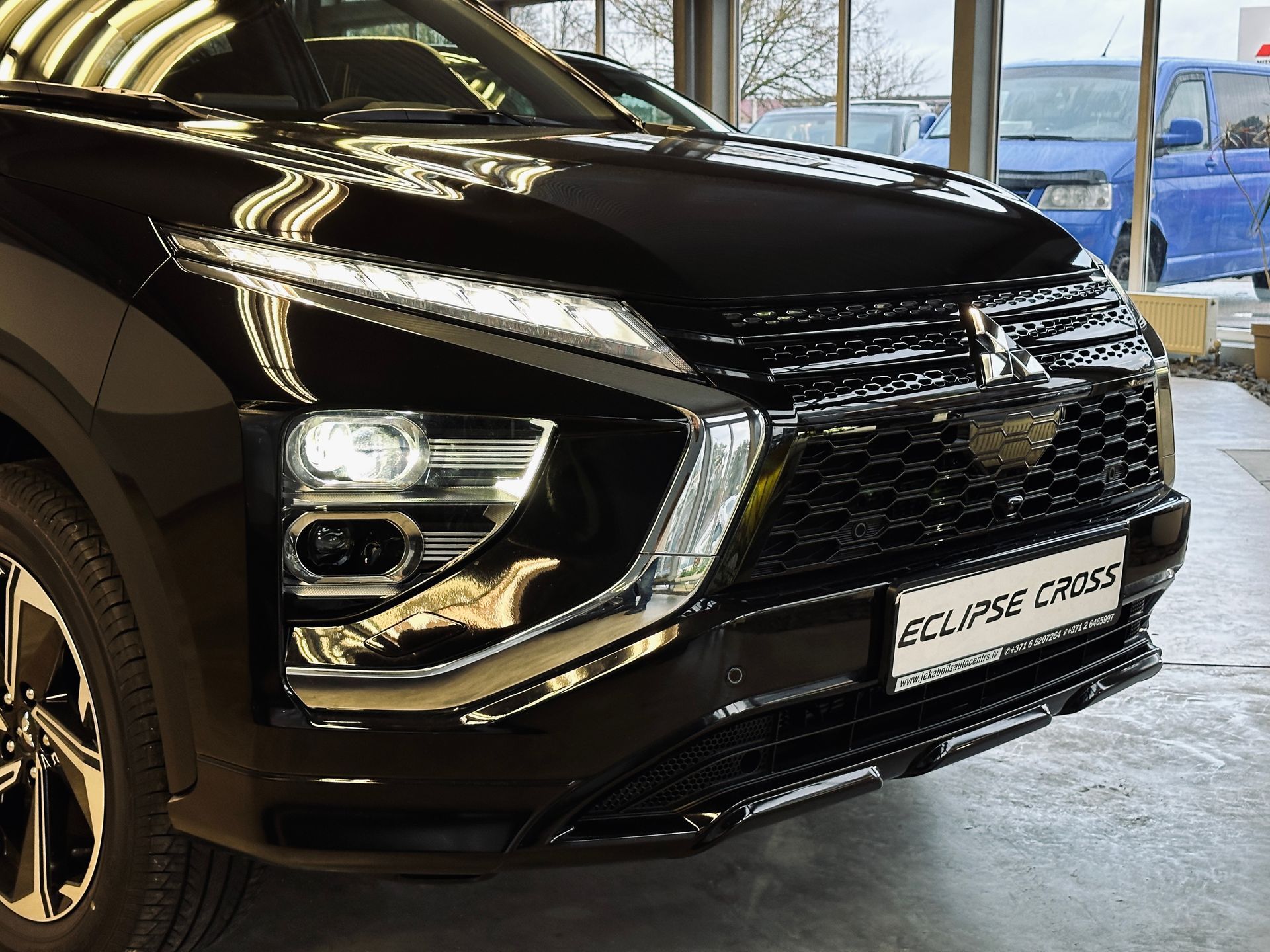 Melns mitsubishi aptumsuma krusts ir novietots izstāžu zālē