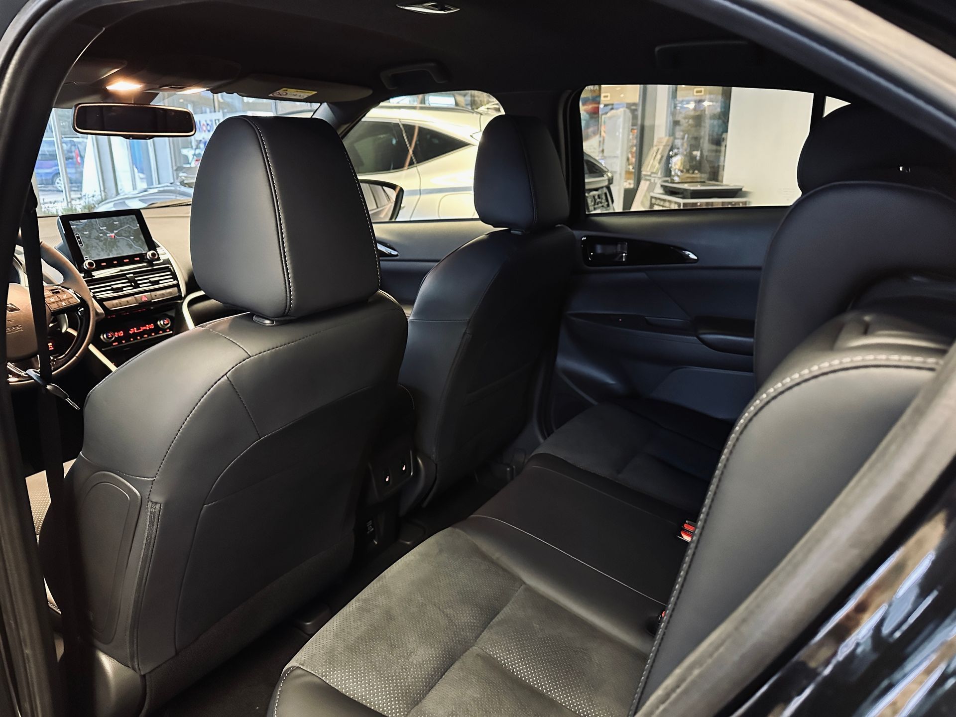 Melnas automašīnas aizmugurējais sēdeklis ar atvērtām durvīm