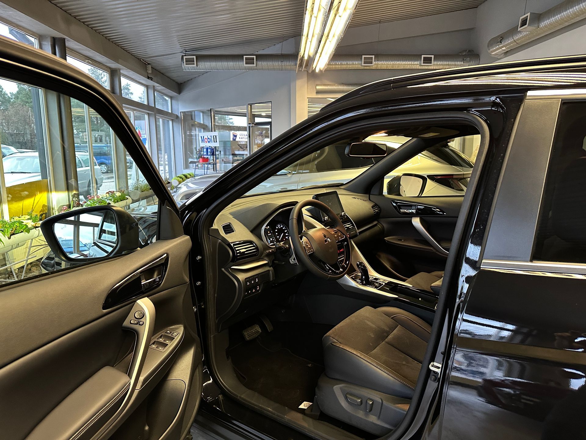 Melnas automašīnas iekšpuse ar atvērtām durvīm