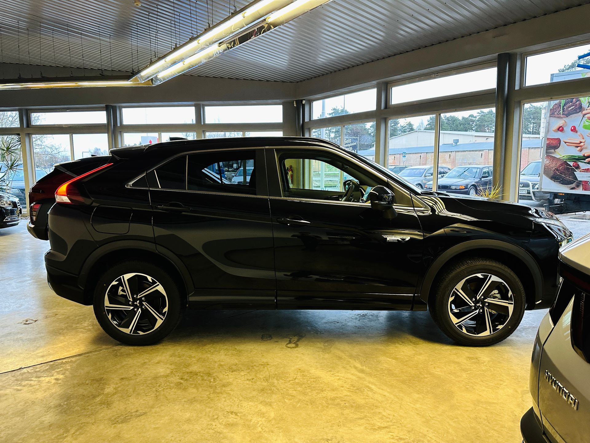 Melns mitsubishi aptumsuma krusts ir novietots izstāžu zālē.