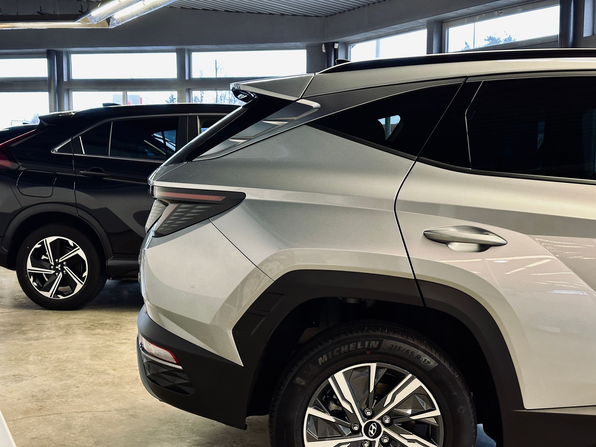 Divas automašīnas ir novietotas blakus viena otrai salonā.