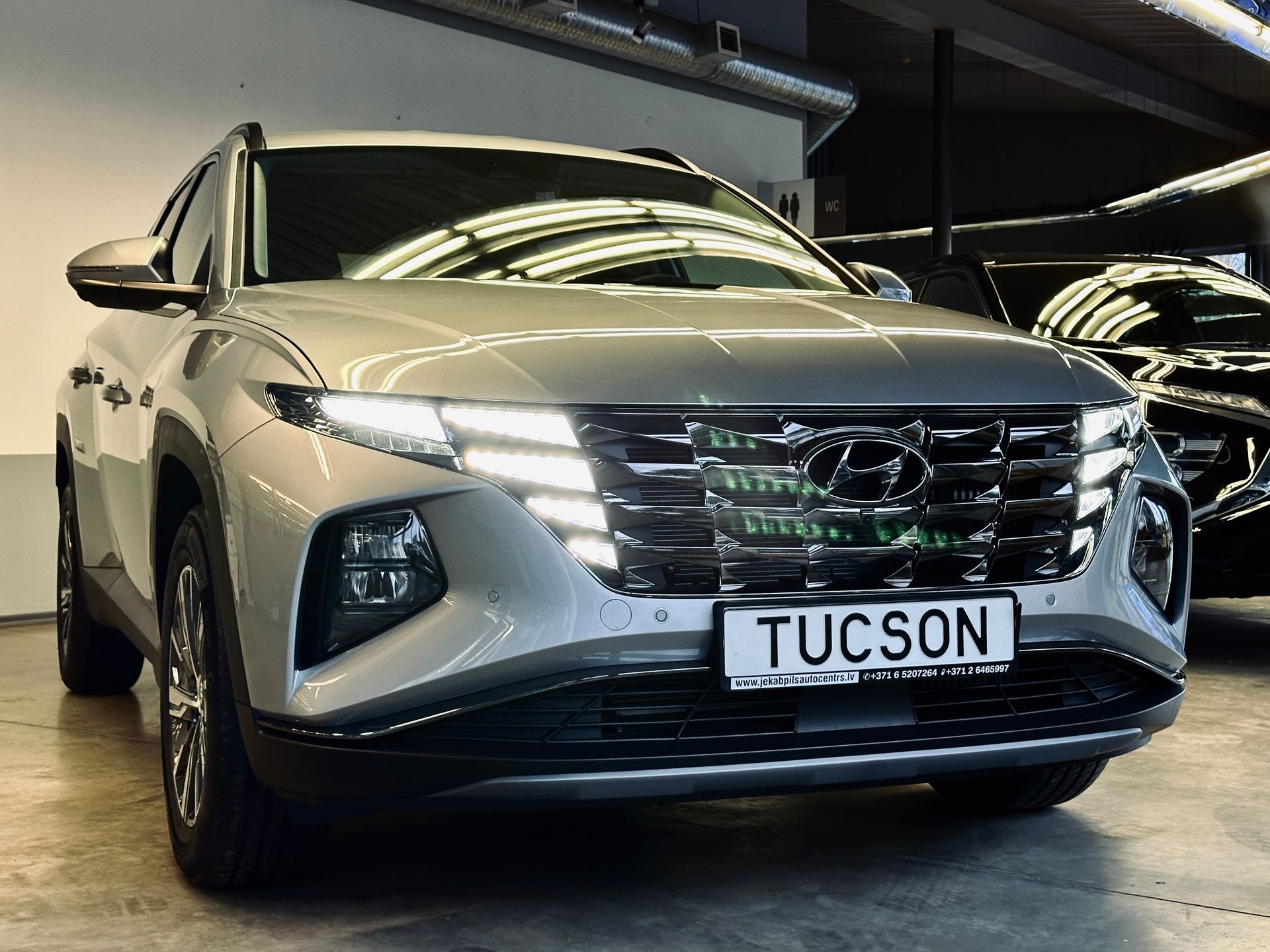 Sudraba hyundai tucson ir novietots izstāžu zālē.