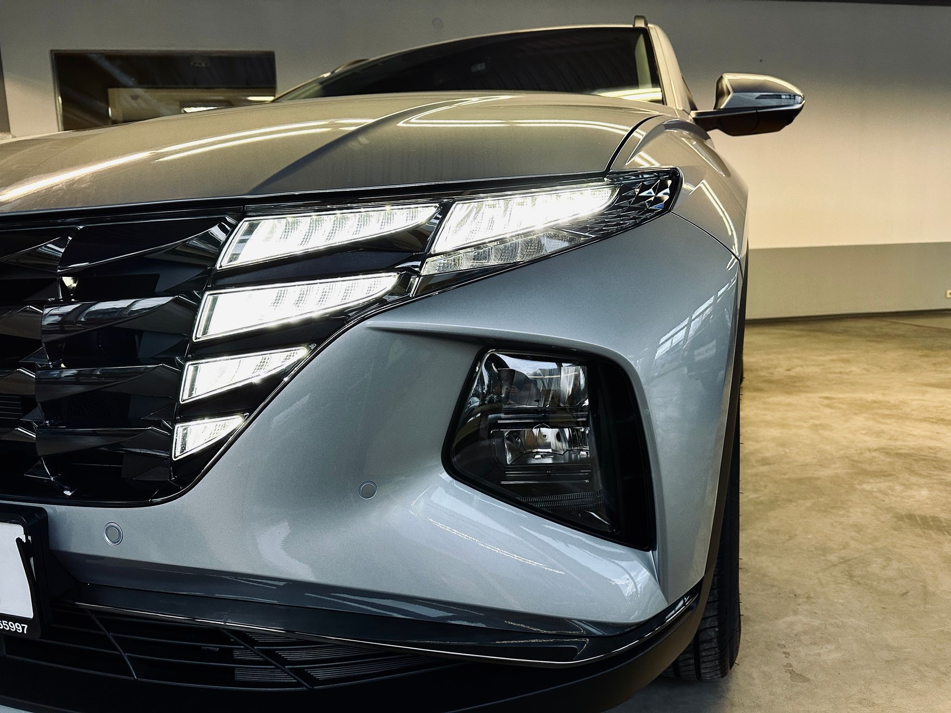 Sudraba auto stāv garāžā.