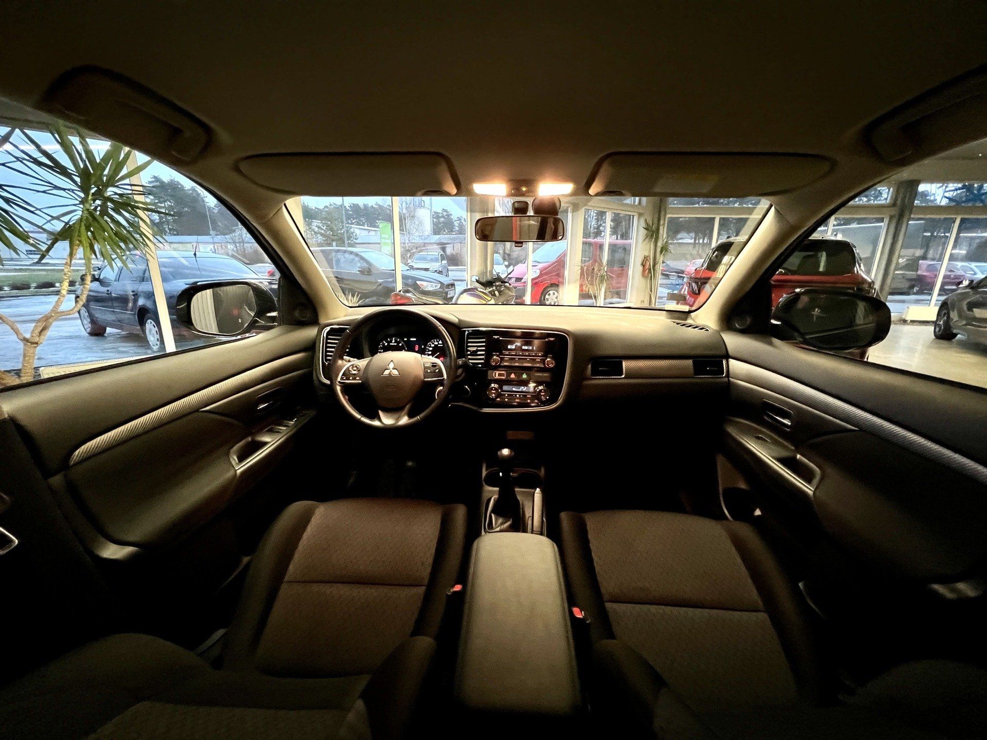 Automašīnas iekšpuse ar stūri un instrumentu paneli.