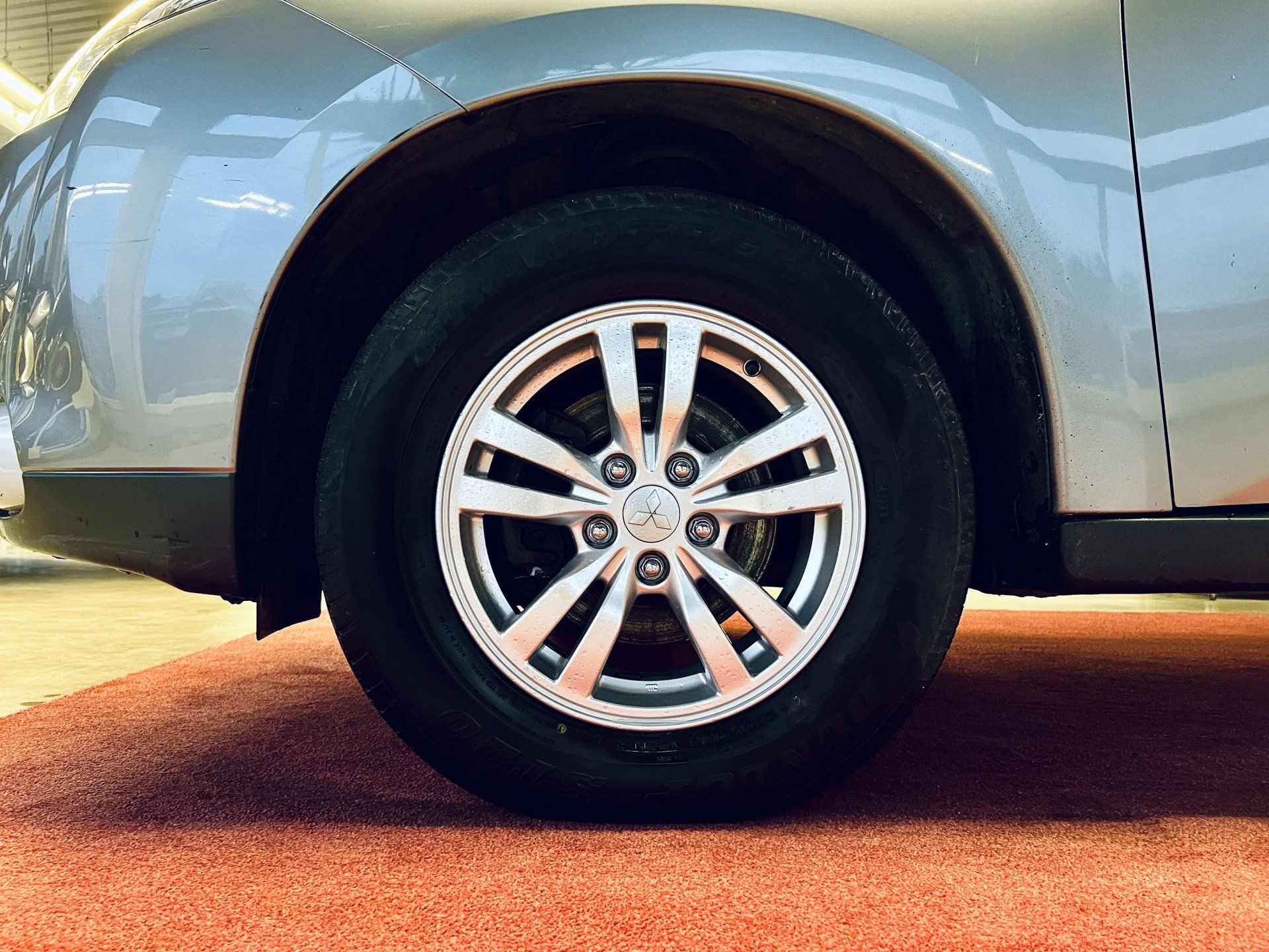 Tuvplāns no automašīnas riteņa uz sarkanā paklāja.