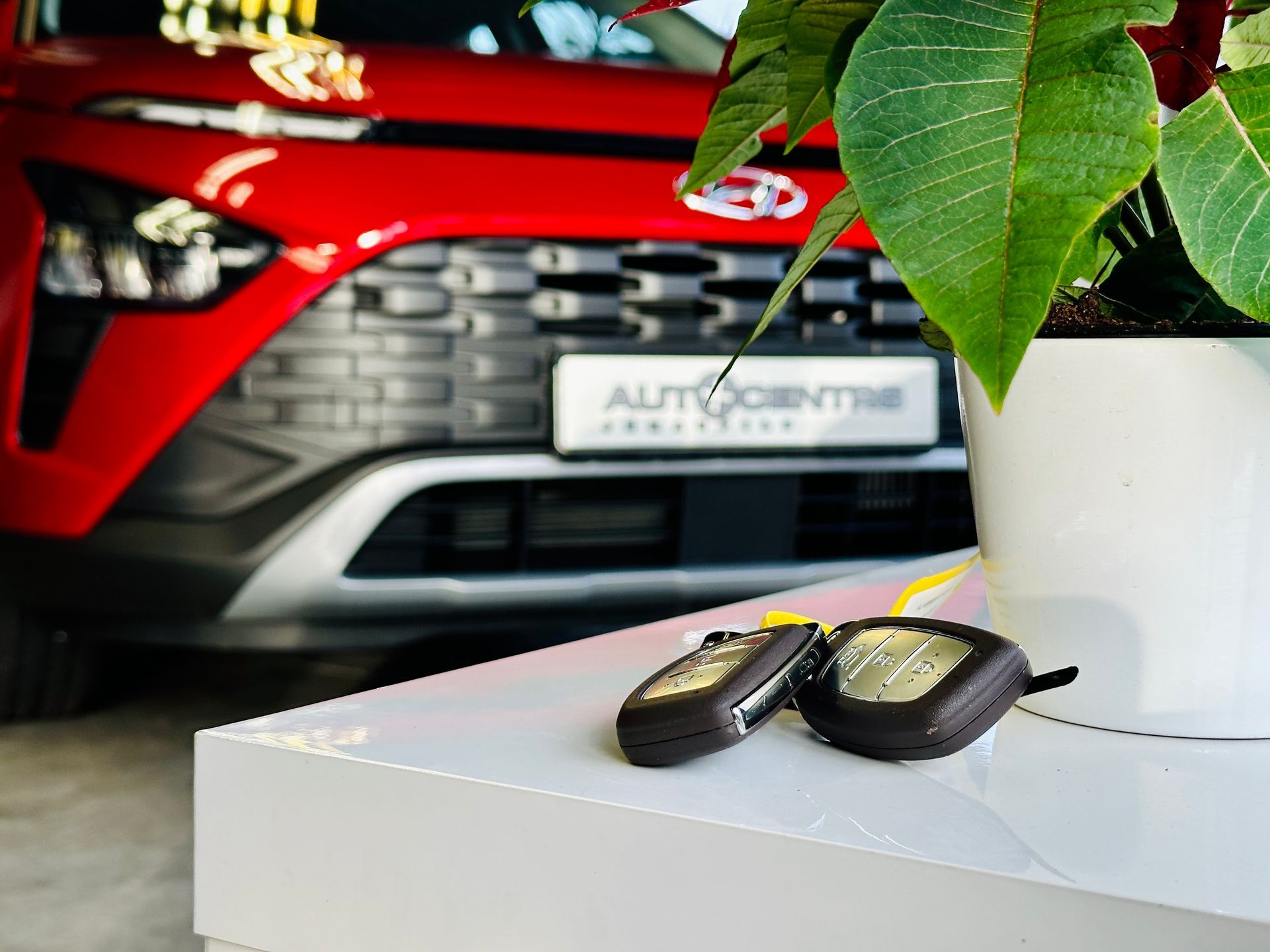 Sarkana mašīna ir novietota pie stāda podos