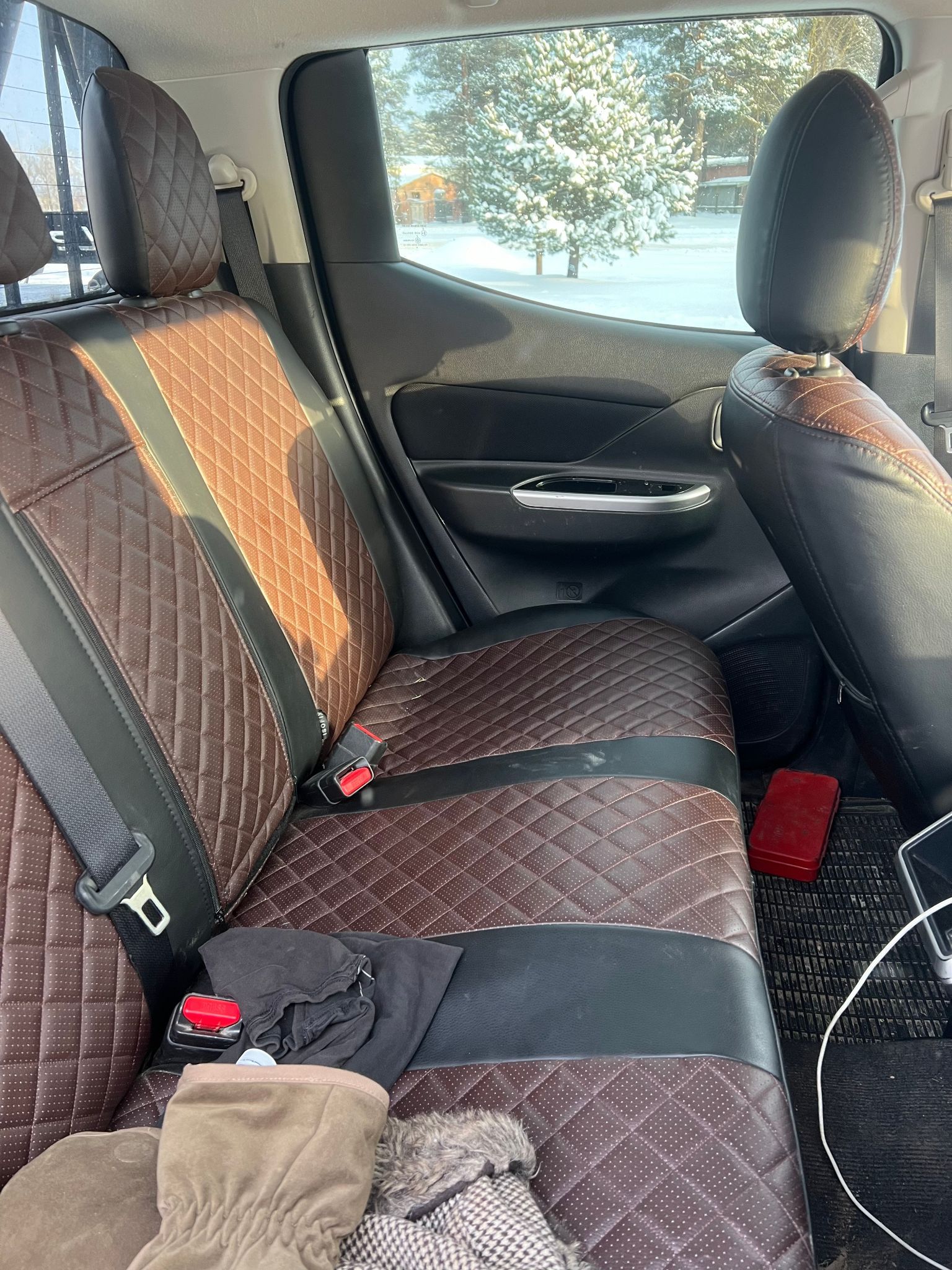 Automašīnas aizmugurējais sēdeklis ar drošības jostu.