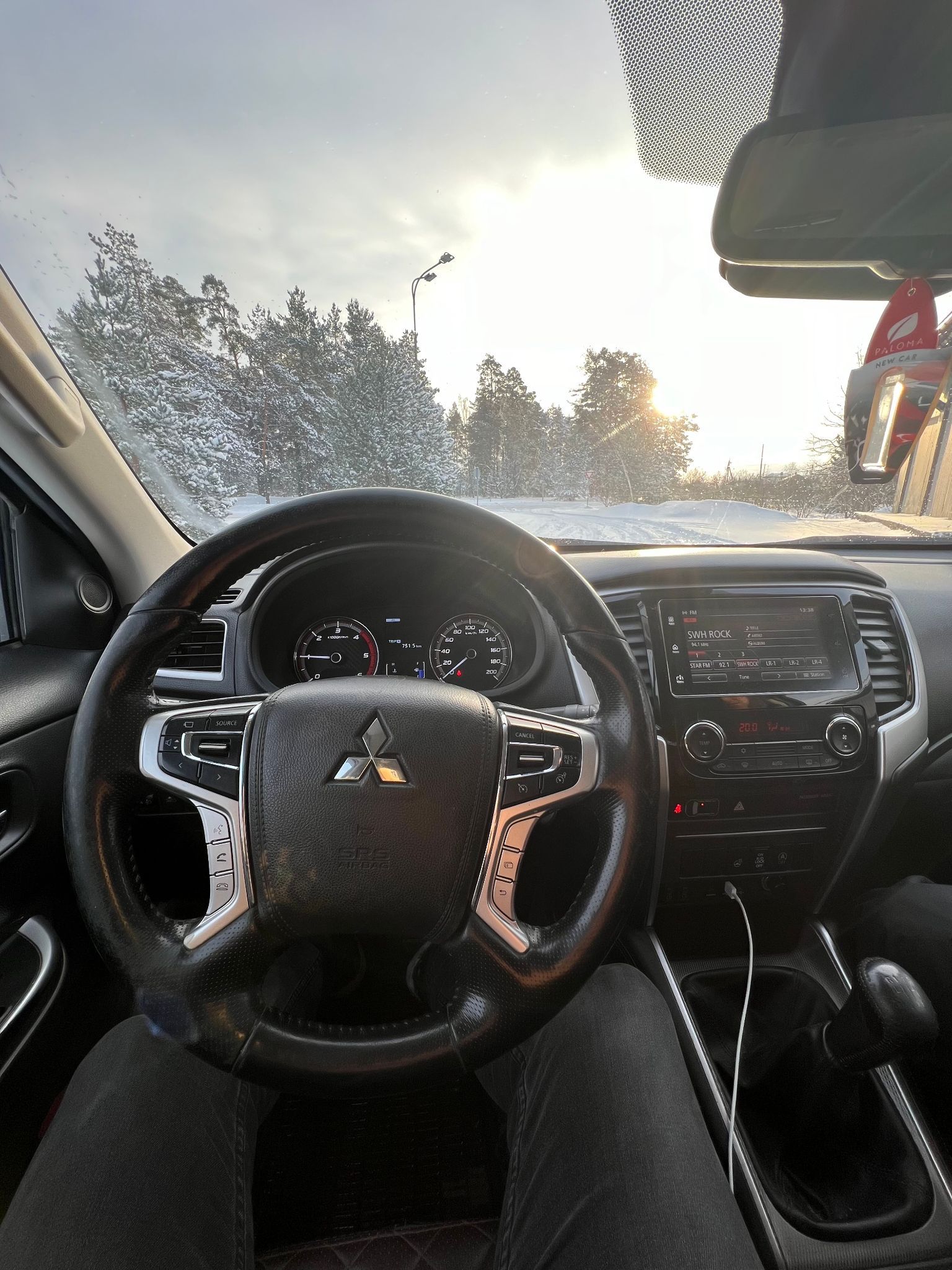 Persona sēž automašīnas vadītāja sēdeklī.