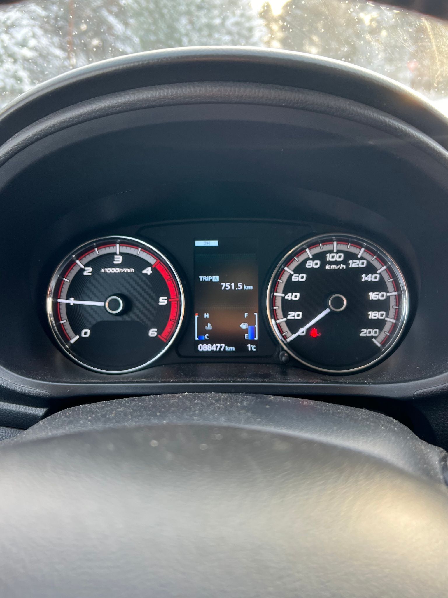 Tuvplāns no automašīnas paneļa ar digitālo displeju.