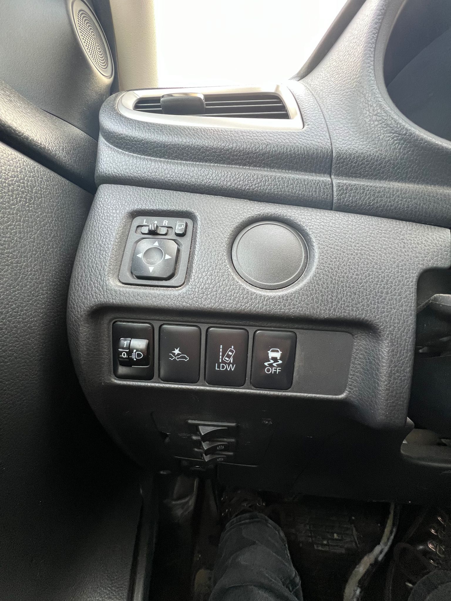 Tuvplāns no automašīnas paneļa ar cilvēka kāju uz bremžu pedāļa.