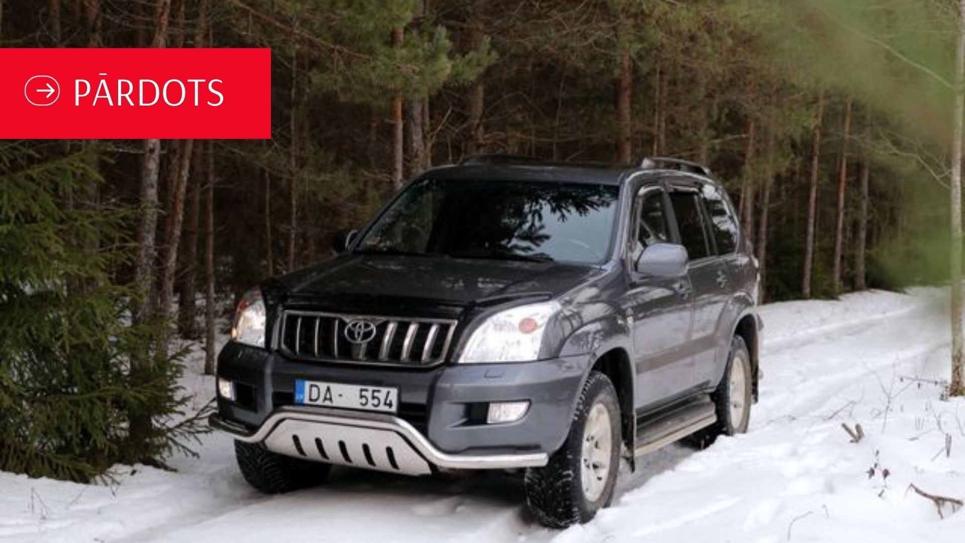 Pa sniegotu ceļu mežā brauc mašīna.