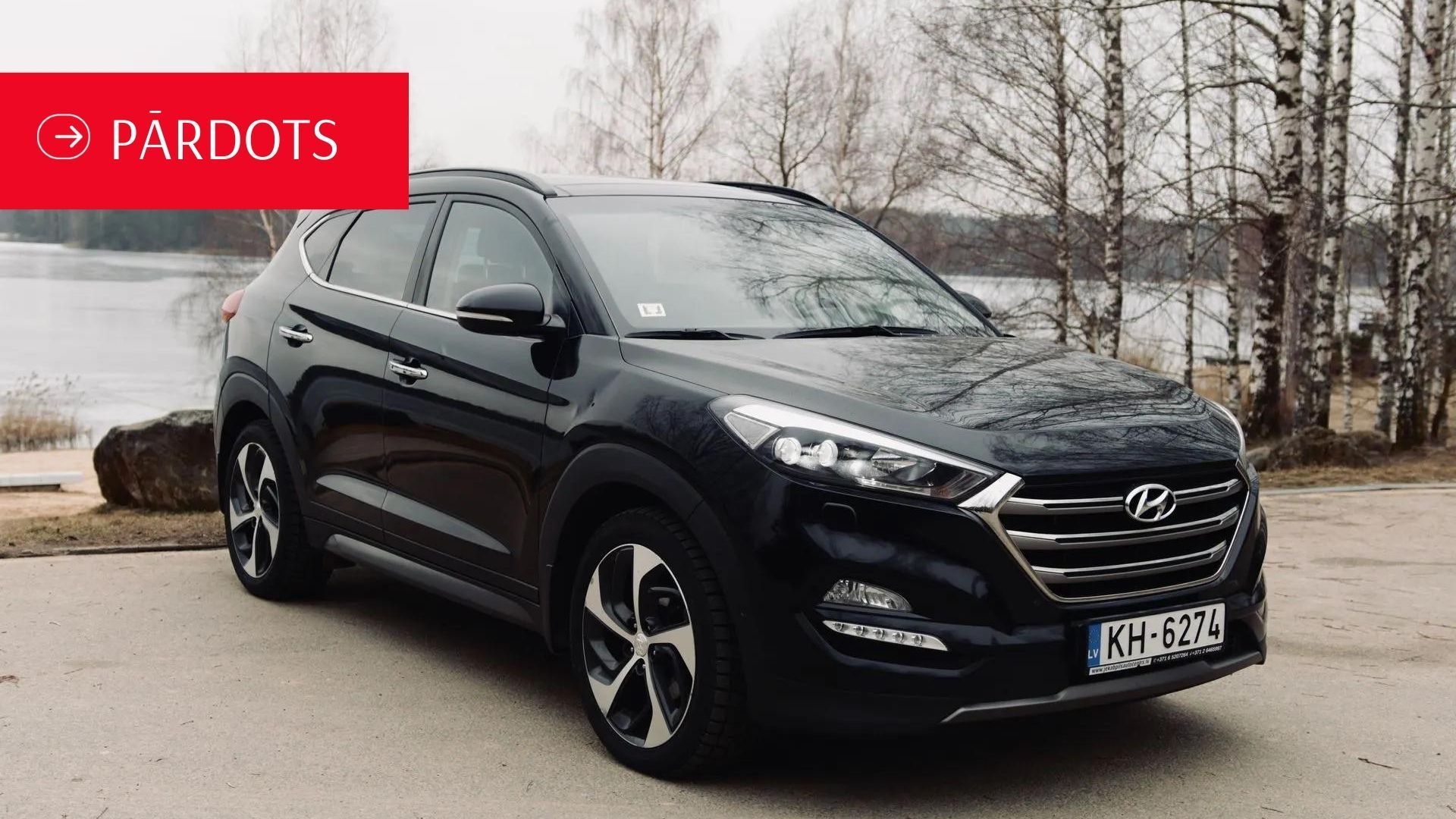 Ūdenstilpes priekšā stāv melns hyundai tucson.