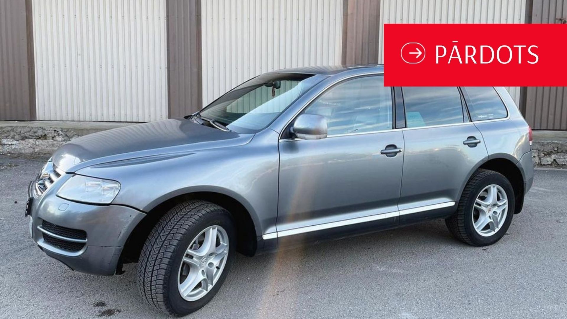 Volkswagen touareg ir novietots garāžas priekšā.