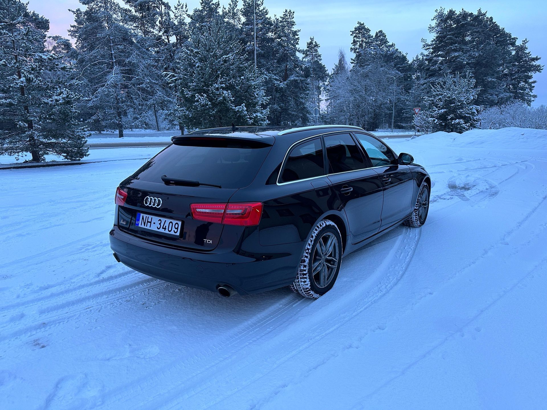 Sniegā stāv melns audi a6.