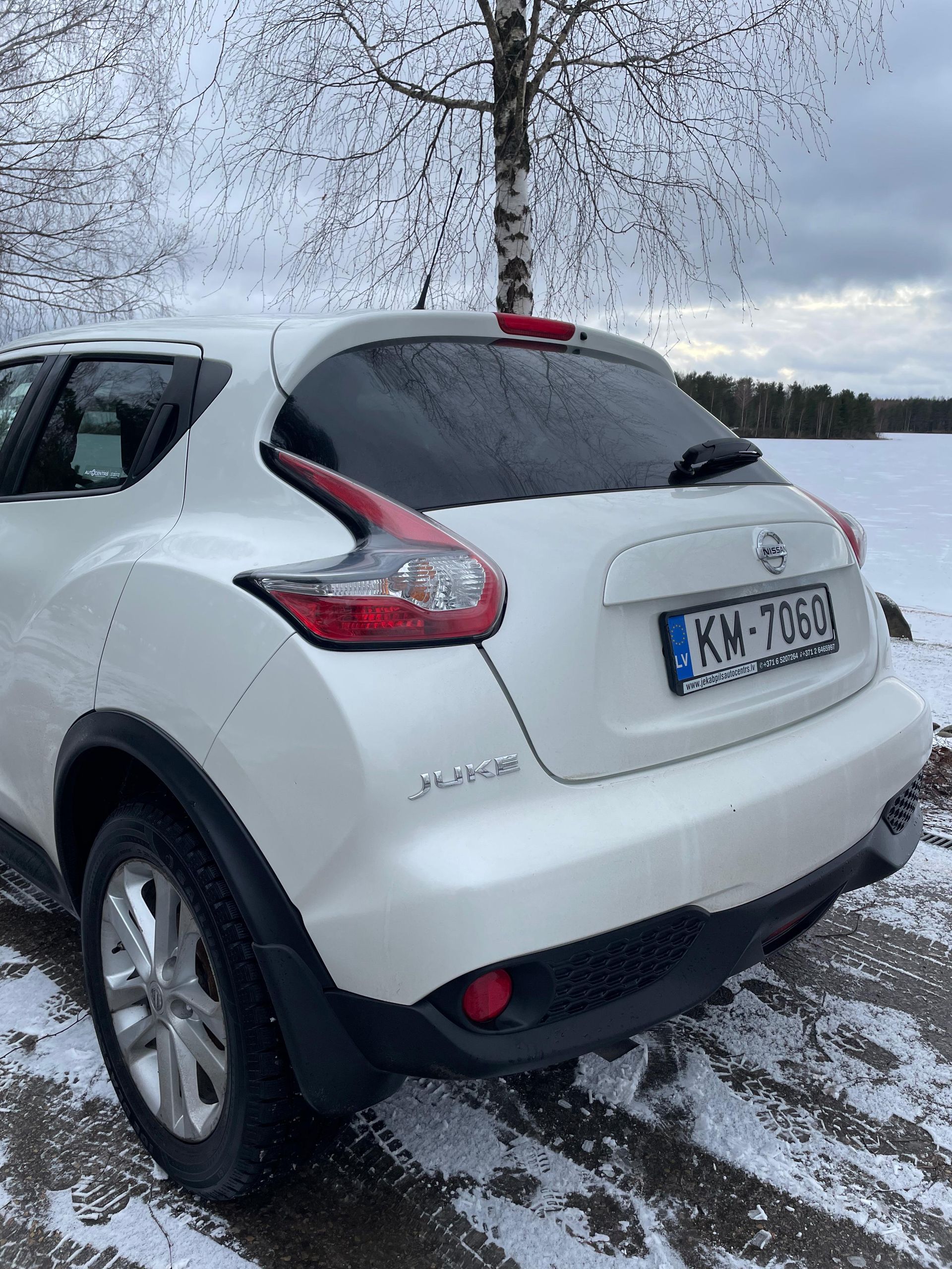 Sniegā stāv balts nissan juke.