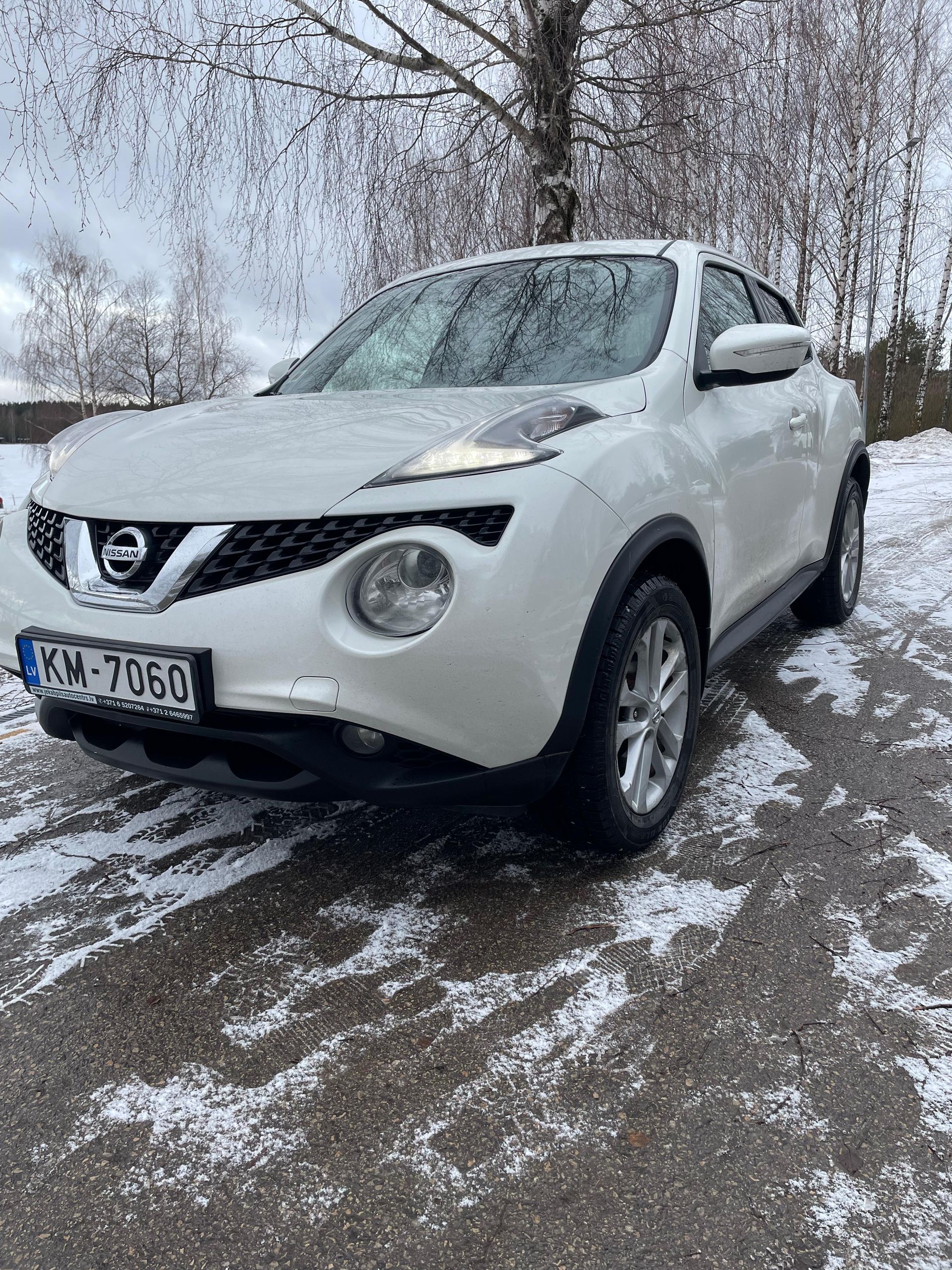 Sniegā stāv balts nissan juke.