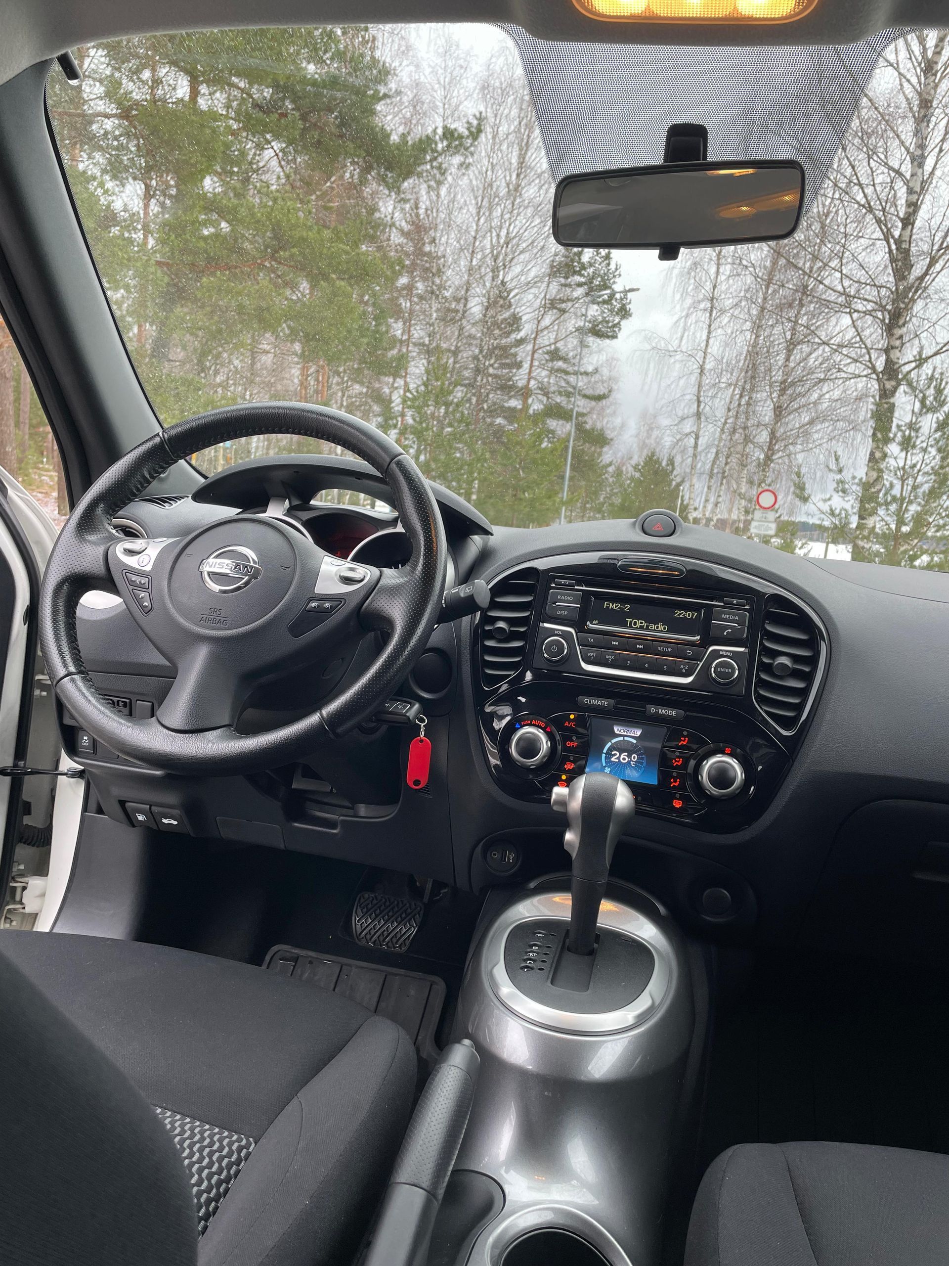 Automašīnas salons ar stūri un atpakaļskata spoguli.