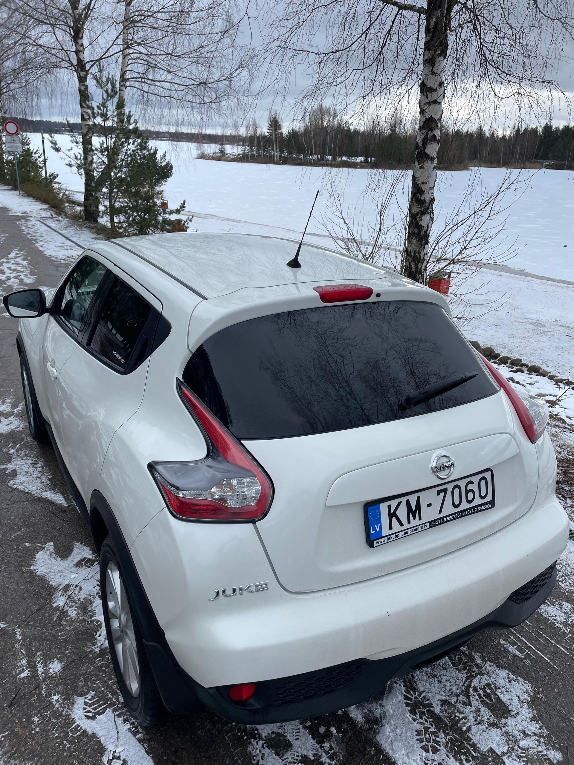 Balta automašīna ar numura zīmi, kurā rakstīts km 2060