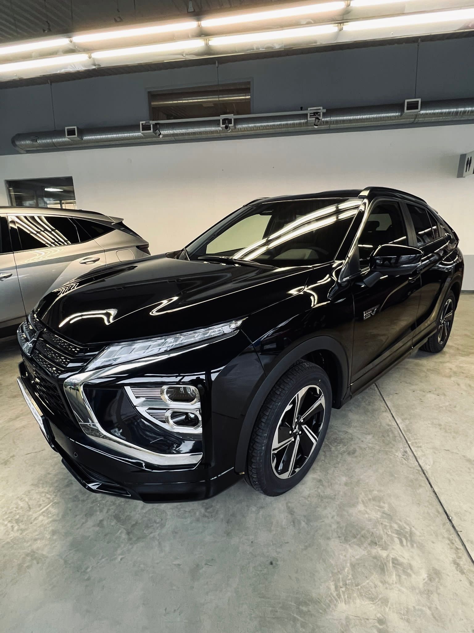 Melna mašīna stāv garāžā.