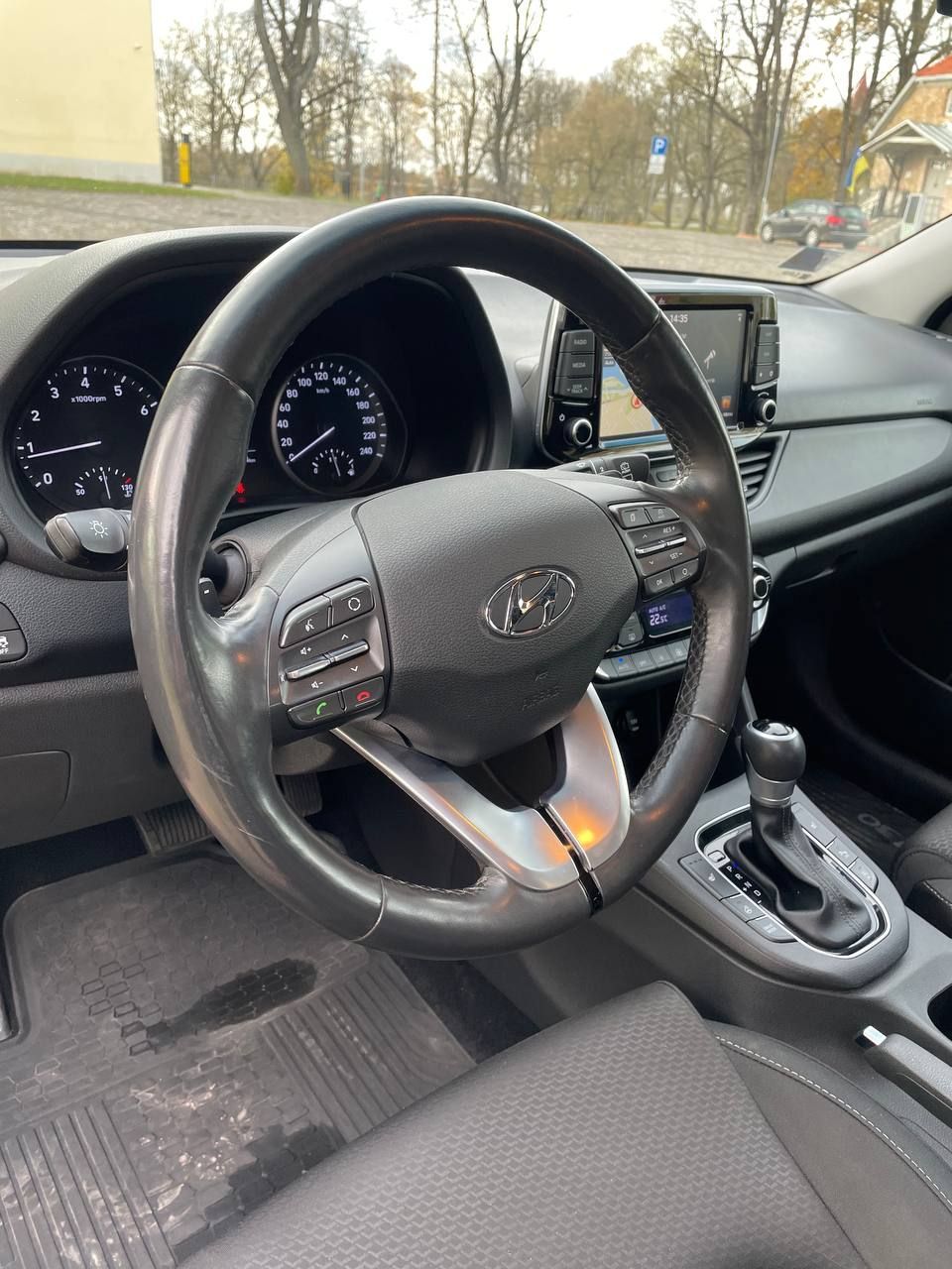 Automašīnas iekšpuse ar stūri un instrumentu paneli.