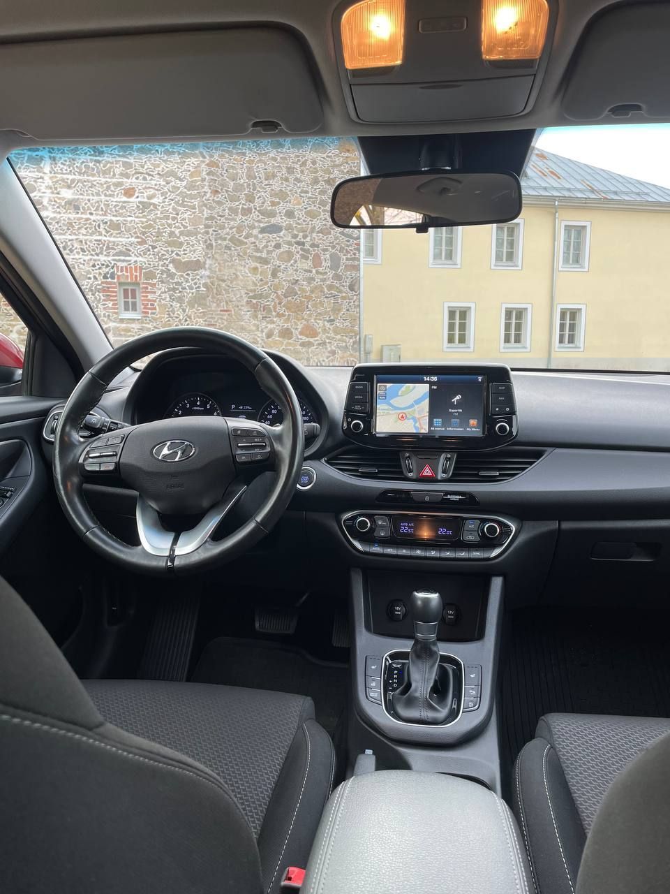 Automašīnas iekšpuse ar stūri un instrumentu paneli.