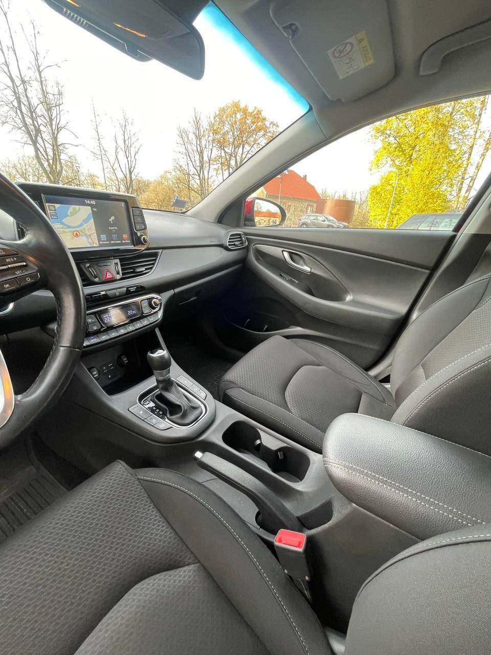 Automašīnas iekšpuse ar stūri un sēdekļiem.