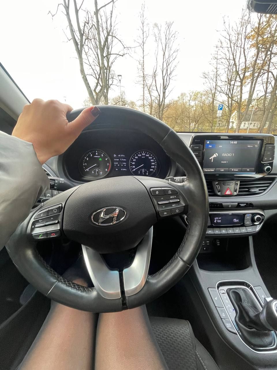 Cilvēks sēž automašīnā, turot stūri.