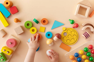 A baby is playing with wooden toys on a table.